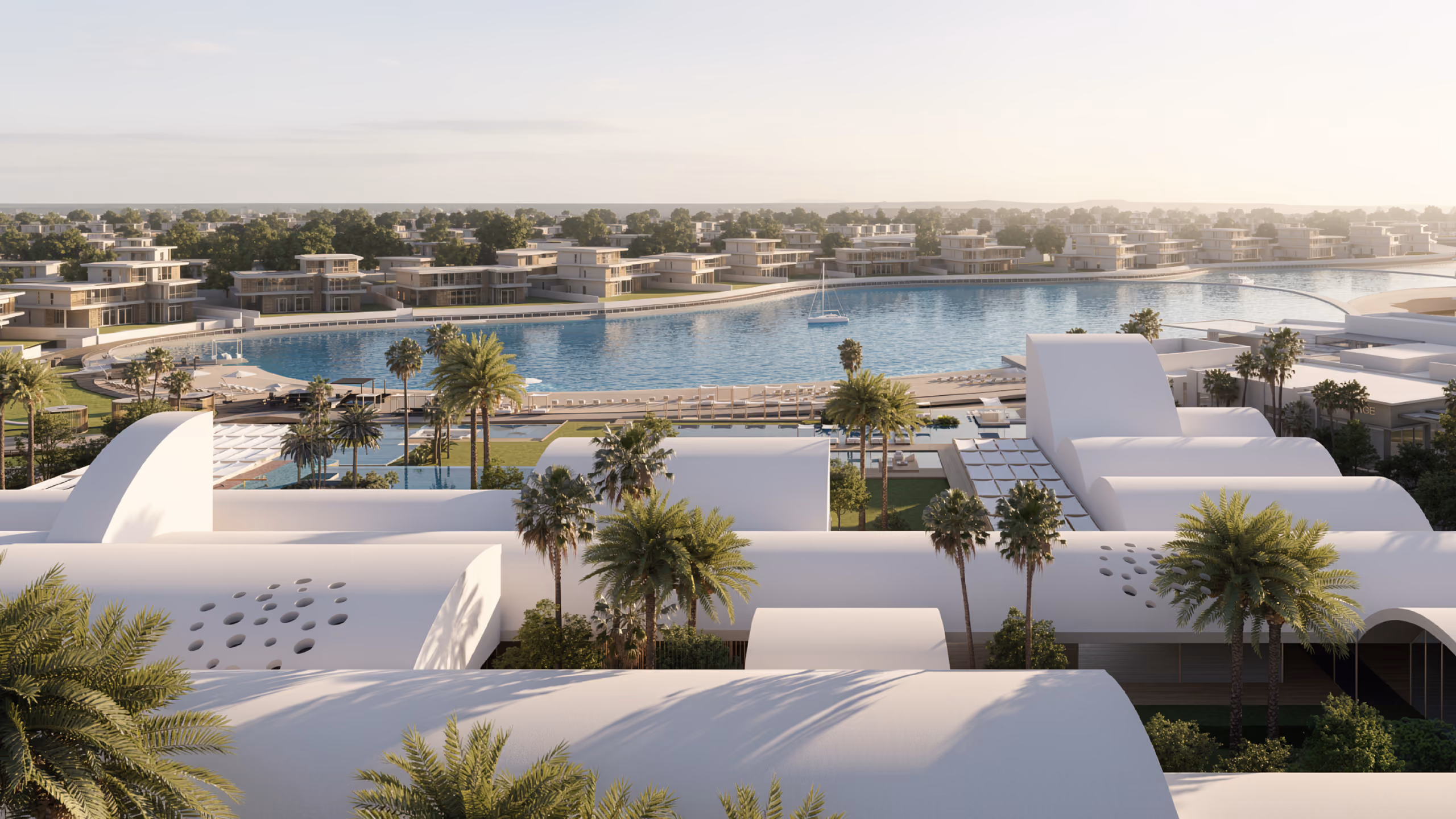 Aerial view of Serenity Beach Club in Dubai, curved white vaulted roofs among palm trees framing a lagoon lined with waterfront villas