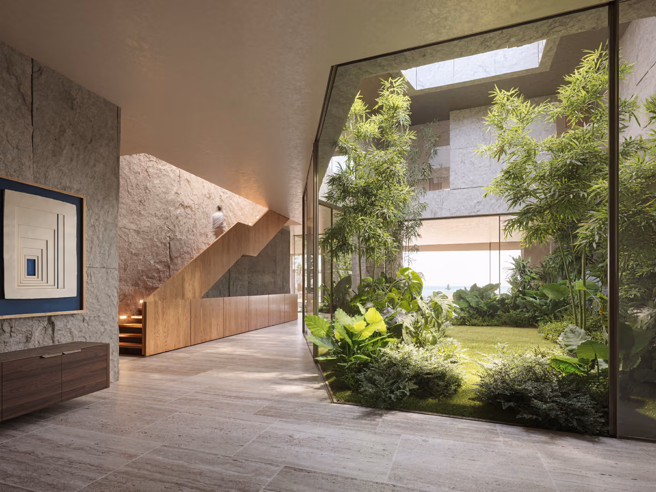 Interior of Geode villa in Dubai, stone-clad hallway with a timber staircase beside a glazed courtyard filled with lush greenery and sea views beyond