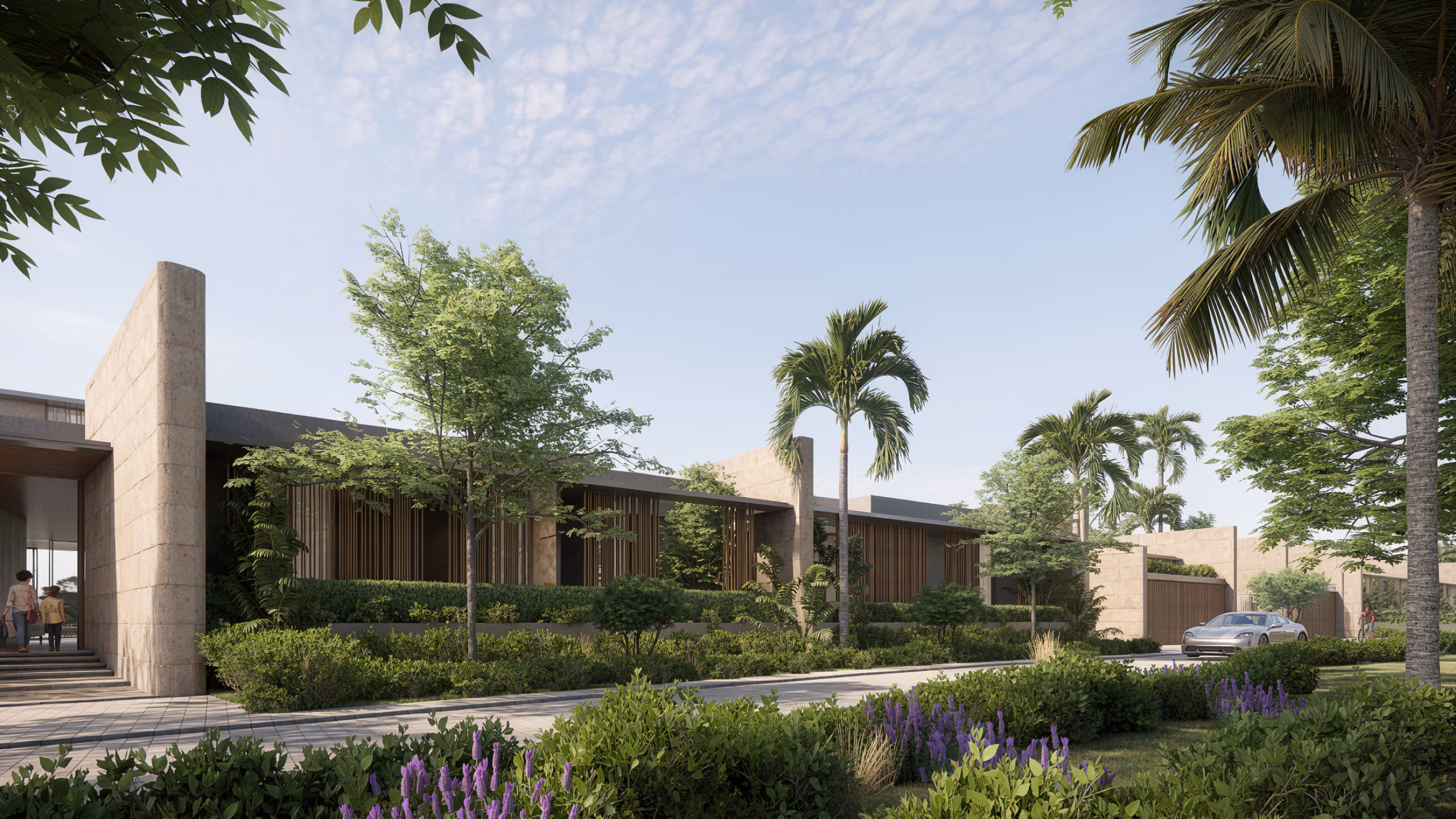 Low-rise stone-clad villa at Beach Club Villas in Dubai, timber screens and palm trees lining a landscaped driveway with a car approaching the gate