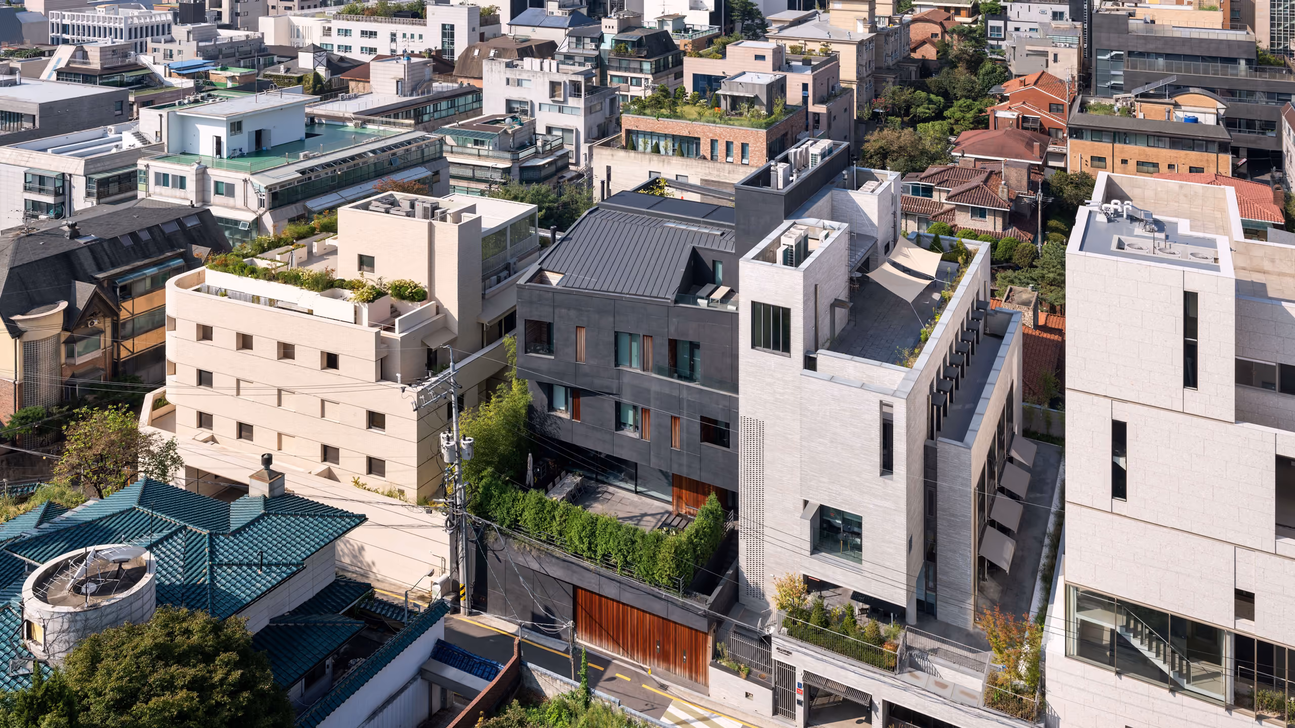 Pyrite, a dark faceted concrete residence by Nabil Gholam Architects, nestled among rooftops and townhouses in a dense Seoul neighbourhood, South Korea