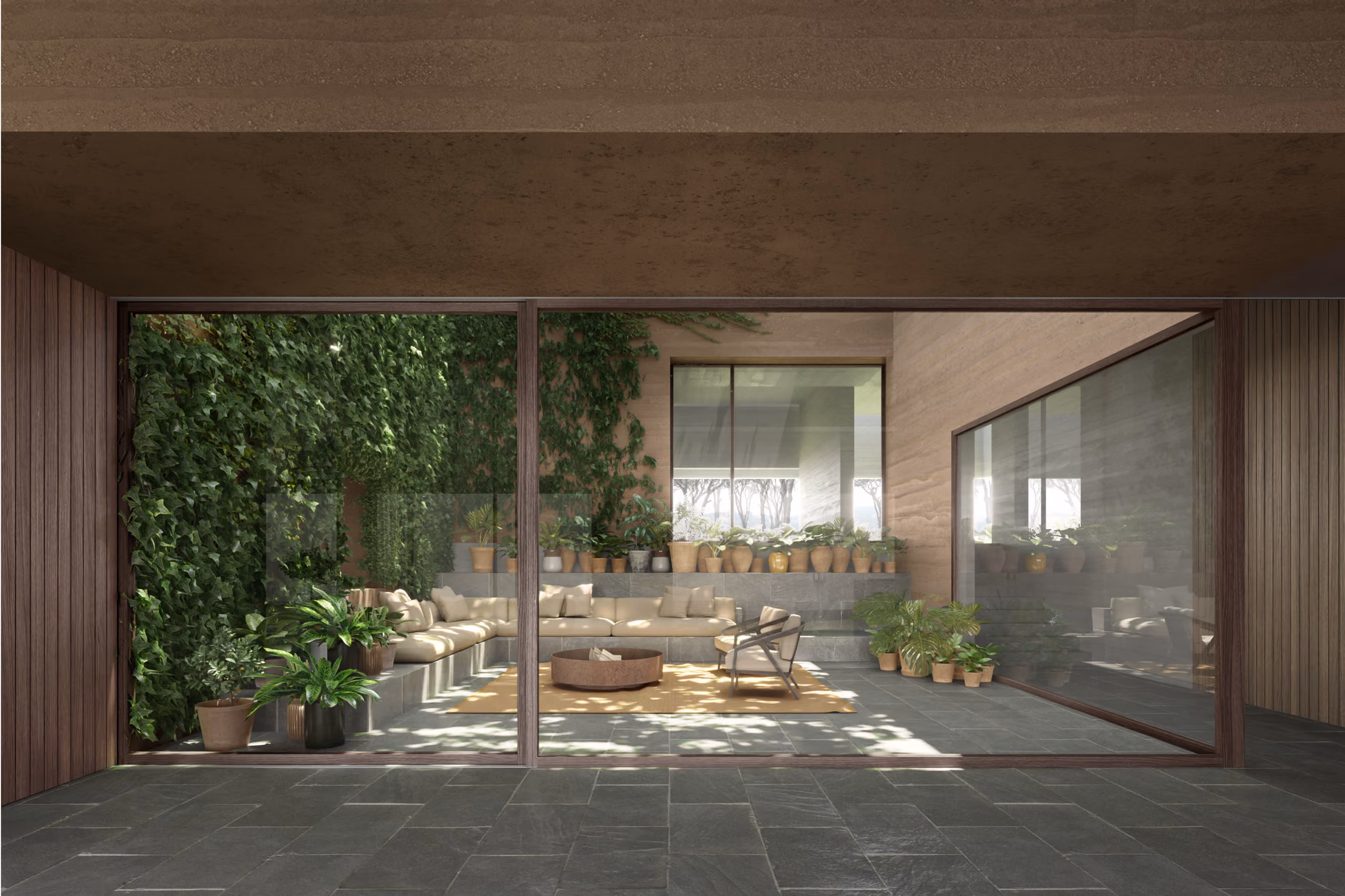 Sunken courtyard lounge at YM House in Deir el Qamar, built-in stone seating and low table framed by glass doors and a lush ivy-covered wall