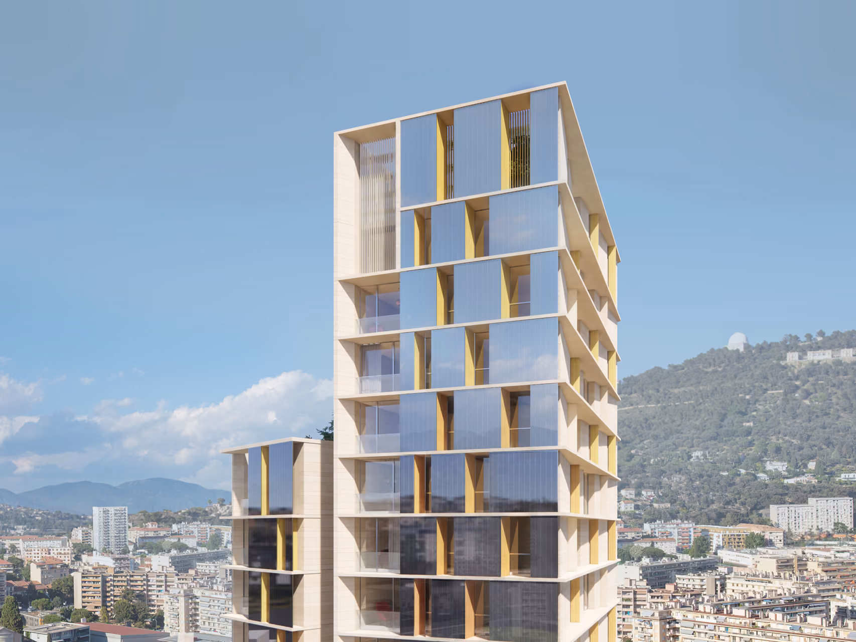 Tour de Nice's stone-clad facade with angled glazed bays and yellow accents, overlooking the hillside city of Nice, France