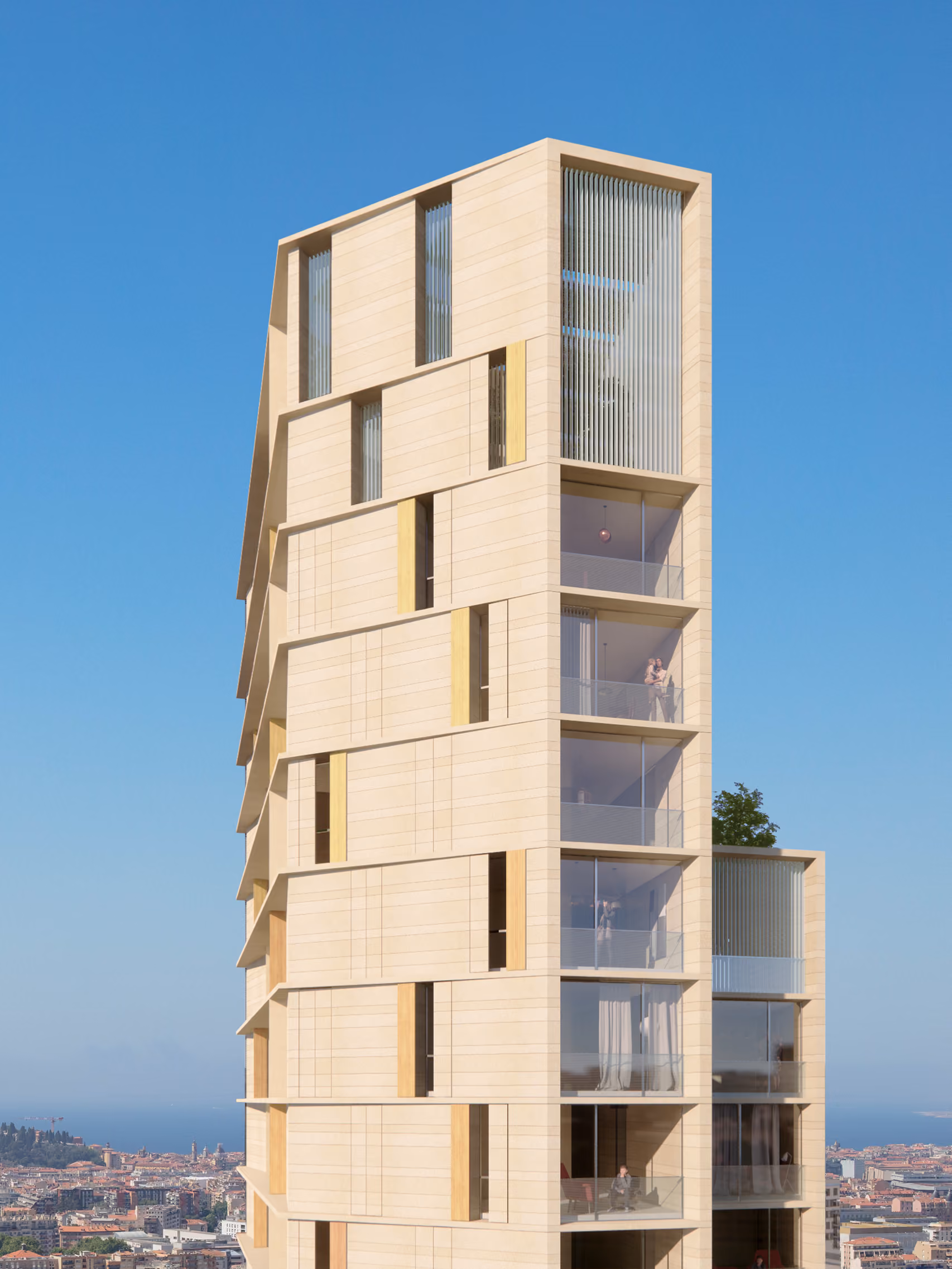 Close-up of Tour de Nice's stone-clad facade, staggered balconies and vertical fins with the city and Mediterranean coastline below