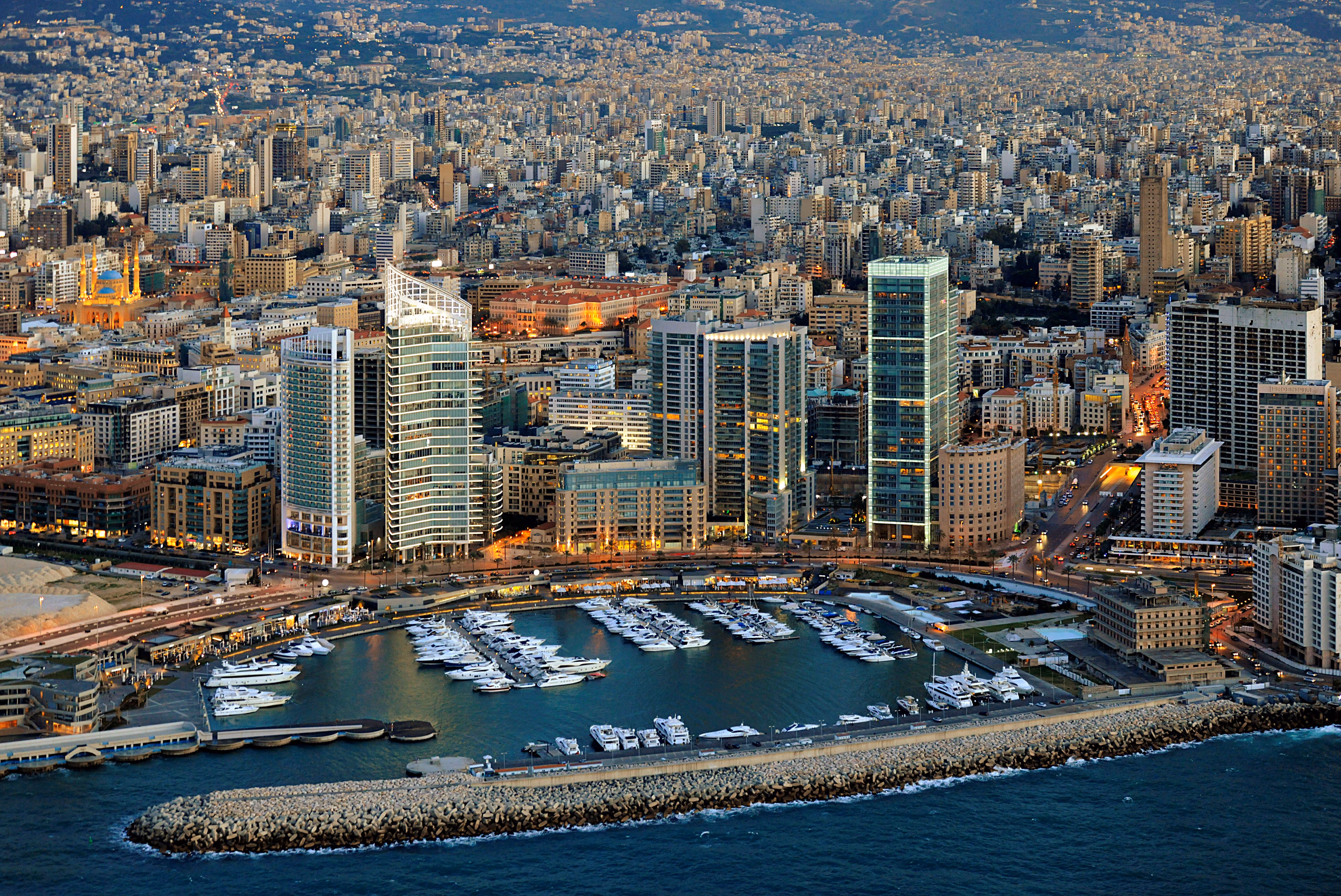 Aerial view of Platinum Tower rising above Beirut's marina, its glass form standing out among the dense skyline of the densely packed city