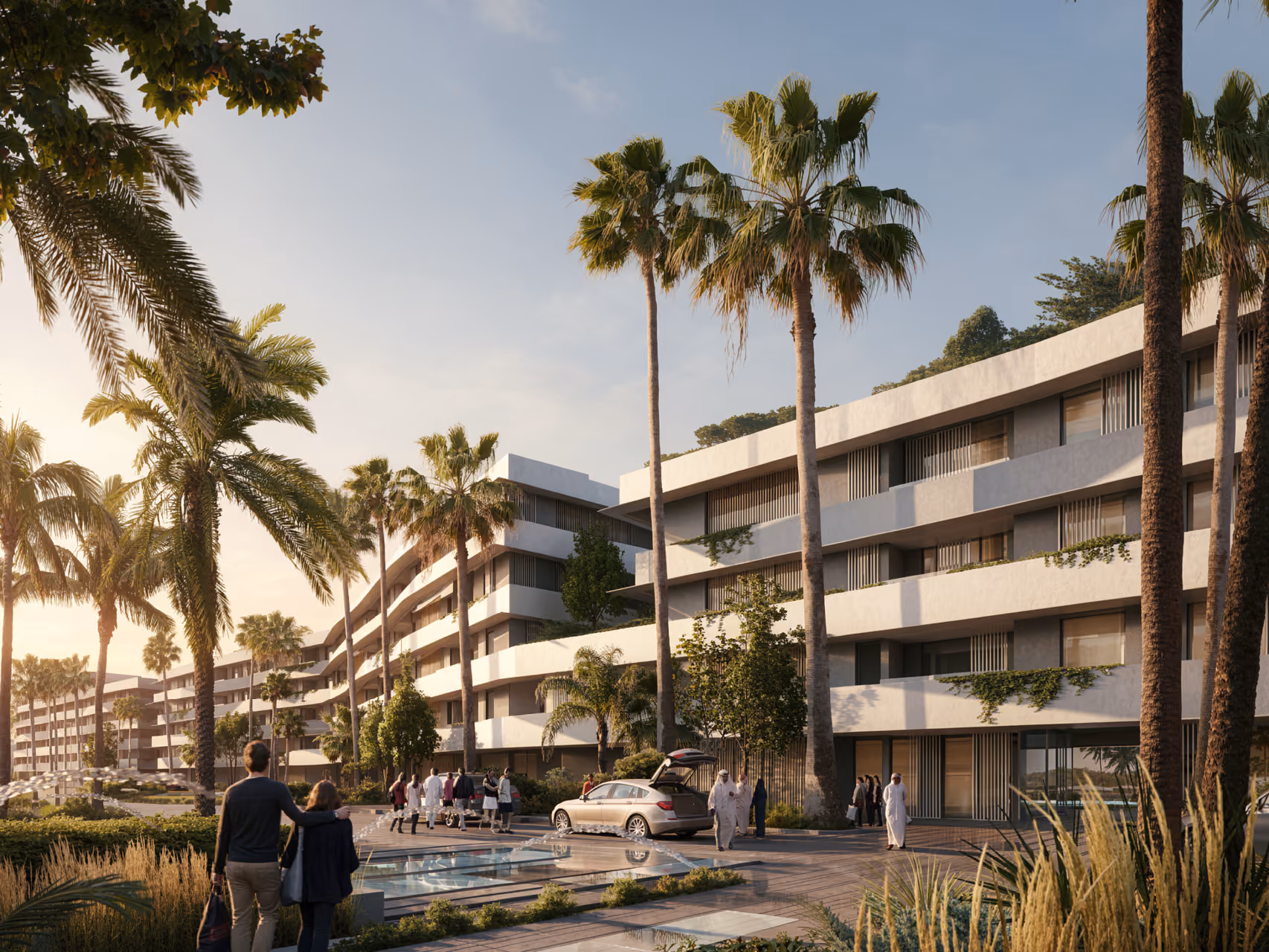 Low-rise terraced residential buildings at Al Zorah Shores in Ajman, framed by tall palm trees with residents and a car along a landscaped waterfront path