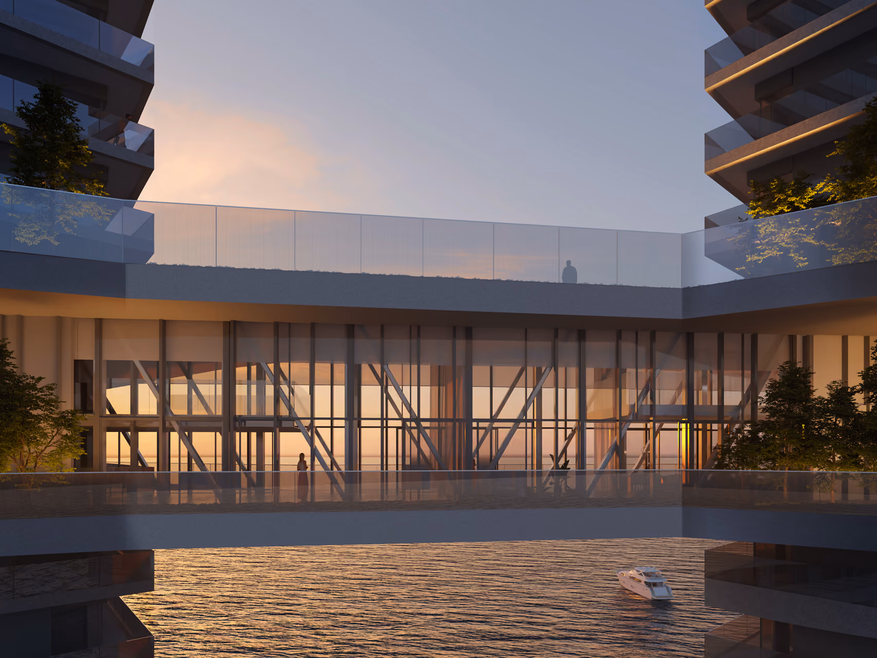 Waterside podium level of Trilliant in Dubai at sunset, diagonal steel bracing visible behind glazing, with a rooftop terrace above and a yacht moored on the water