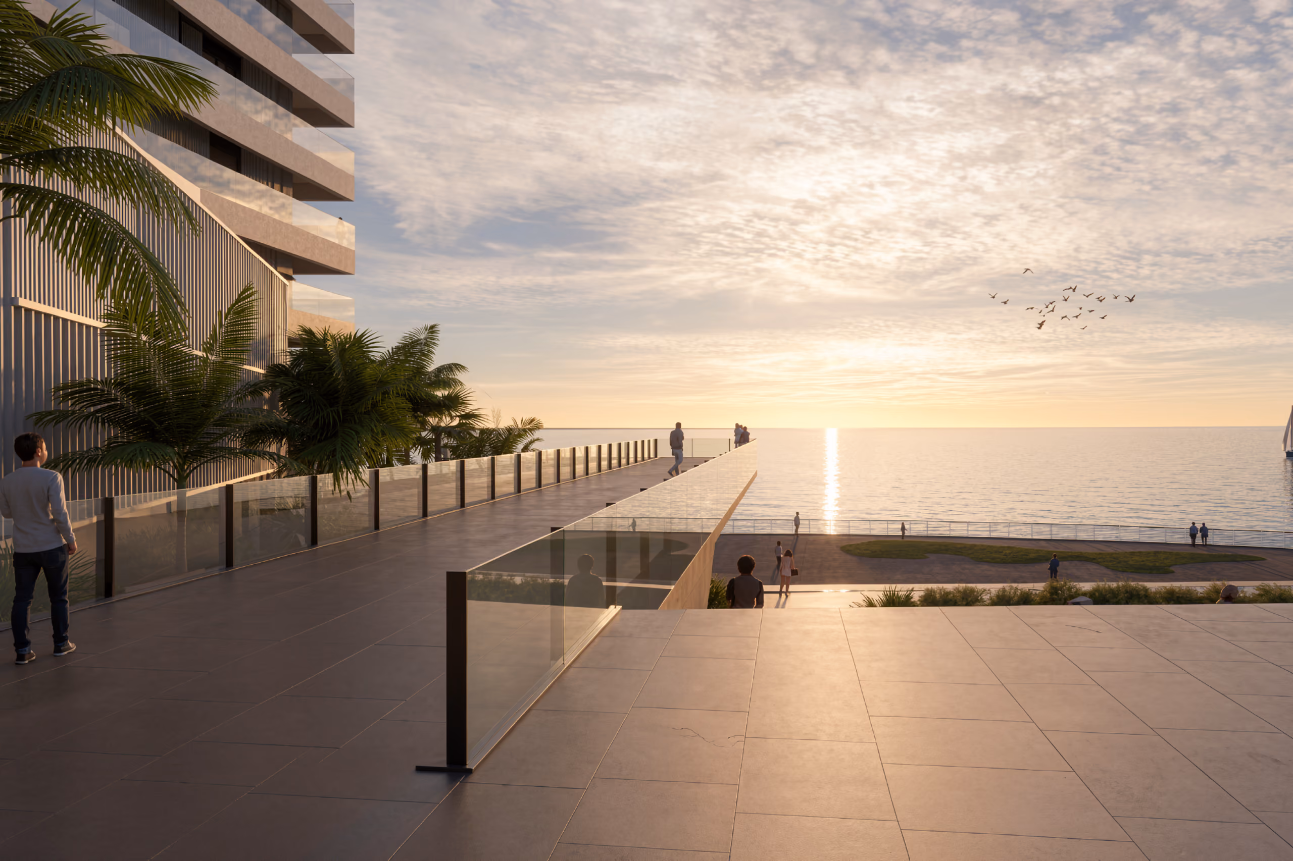 Seafront promenade at Trilliant in Dubai, tiered terraces and glass railings leading toward the sea as visitors walk along the waterfront at sunset