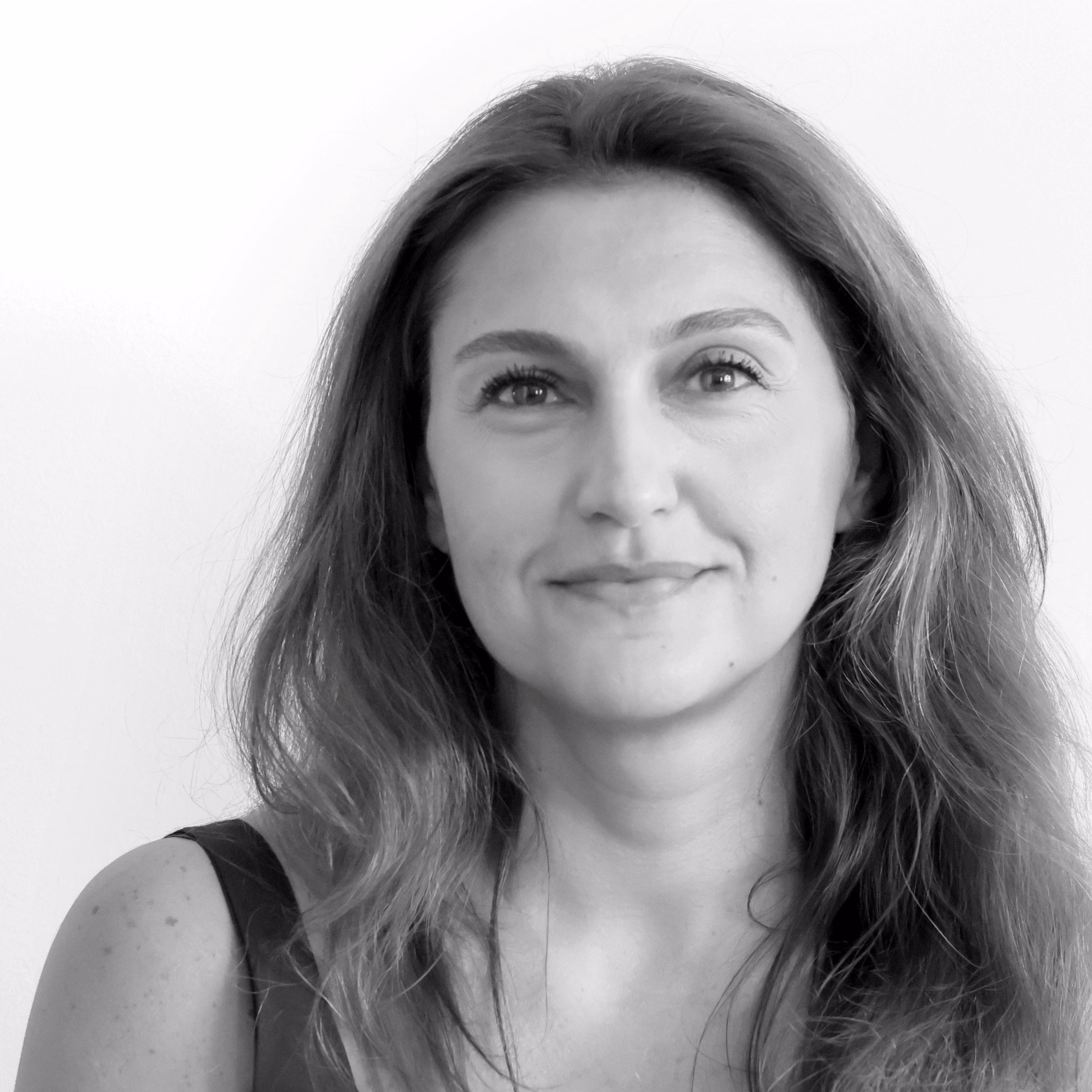 Rania Moujahed, Head of Administration at Nabil Gholam Architects, black and white portrait with long wavy hair, smiling gently