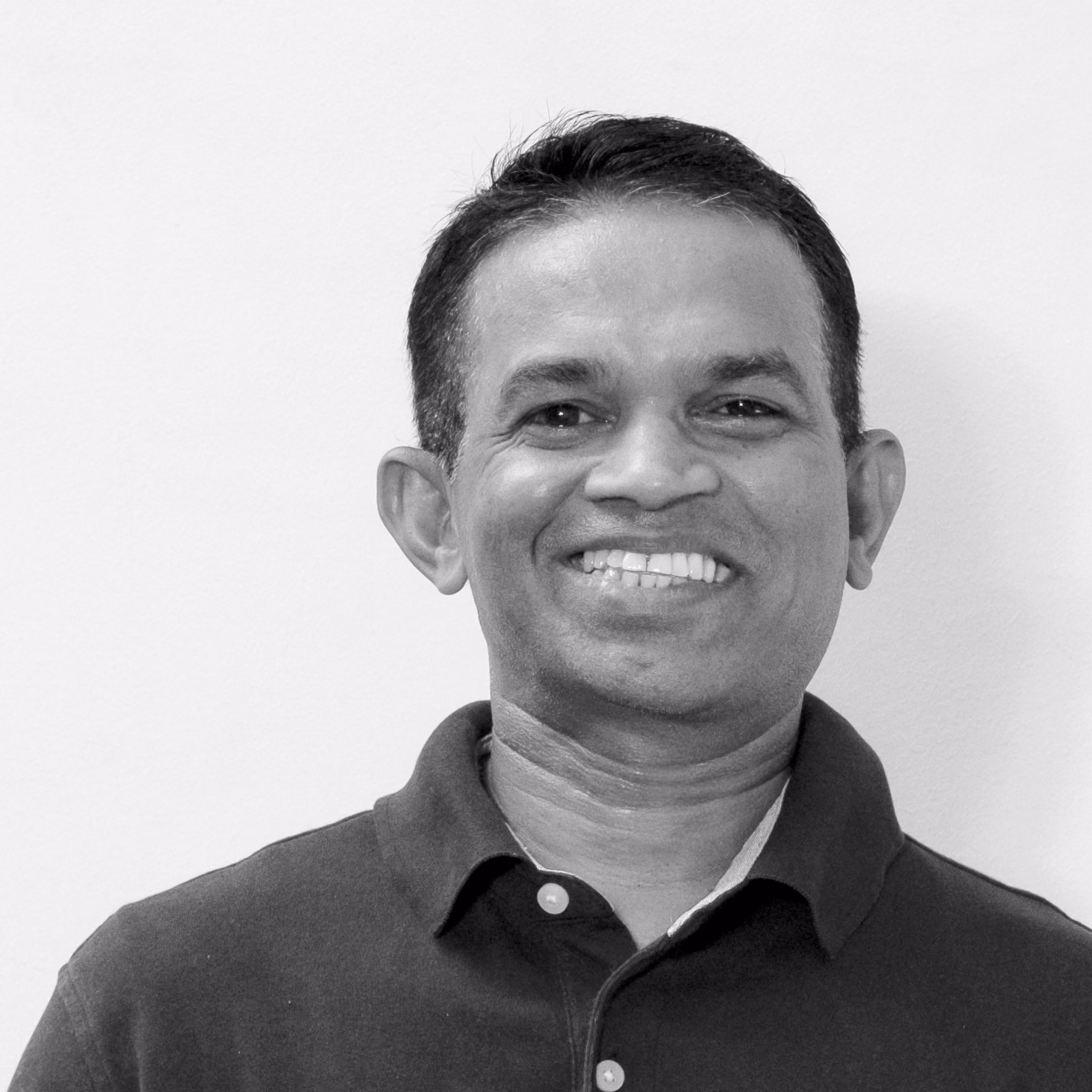 Chintaka Kaludura, Maintenance at Nabil Gholam Architects, black and white portrait smiling in a dark polo shirt