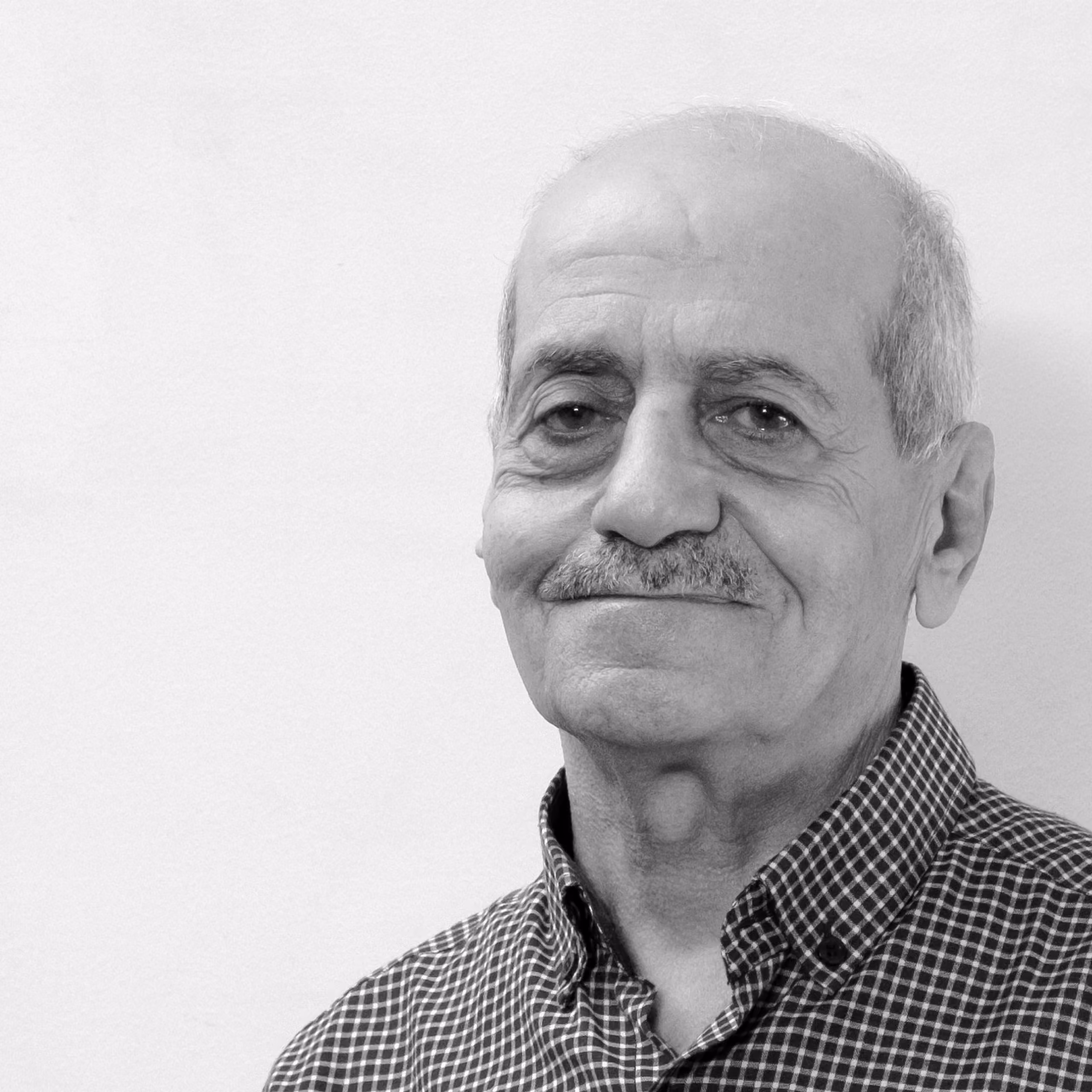 Nabil Alameddine, Senior Assistant at Nabil Gholam Architects, black and white portrait with a moustache, smiling in a checked shirt