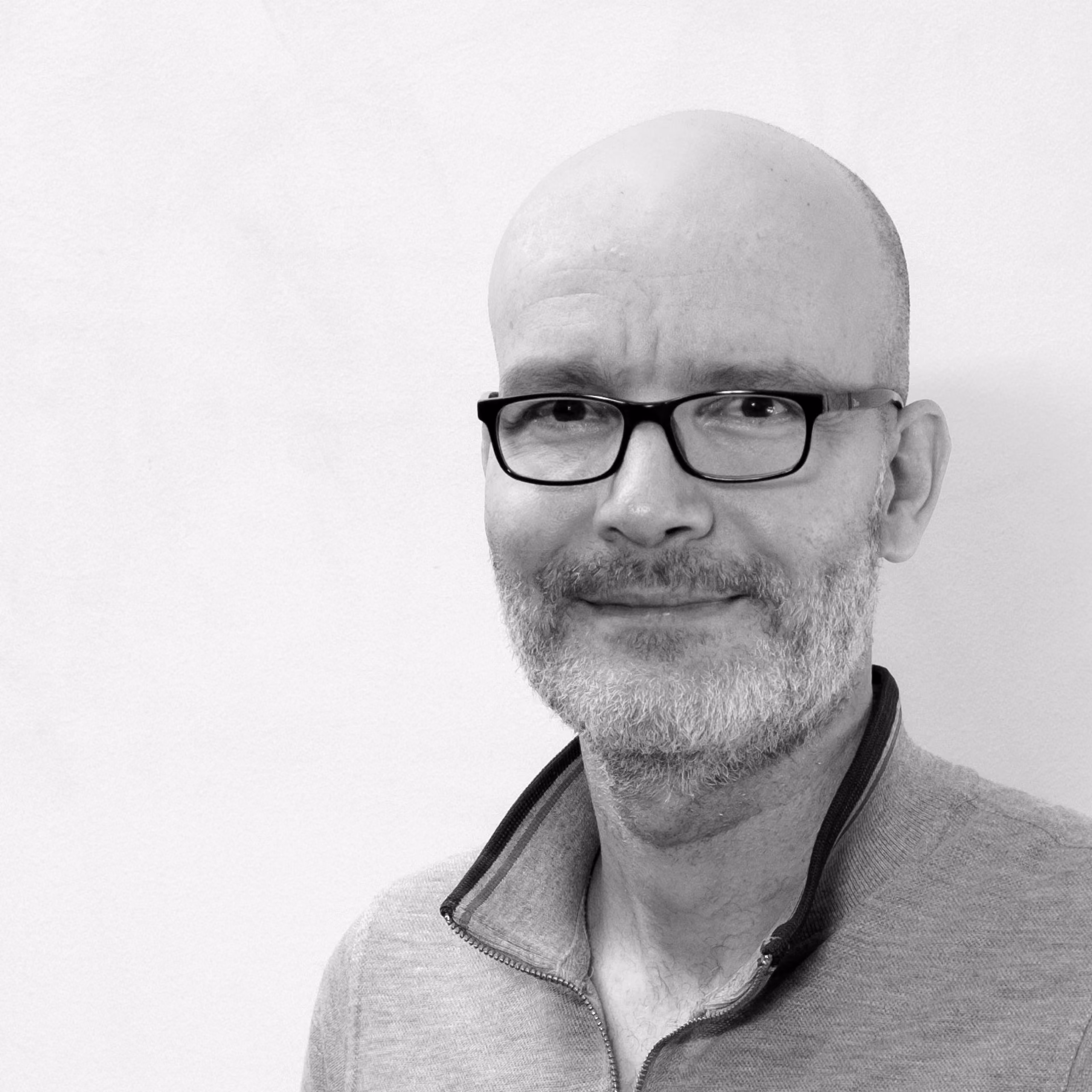 Elie Hachem, Head of IT at Nabil Gholam Architects, black and white portrait with glasses, grey beard and a zip-neck sweater