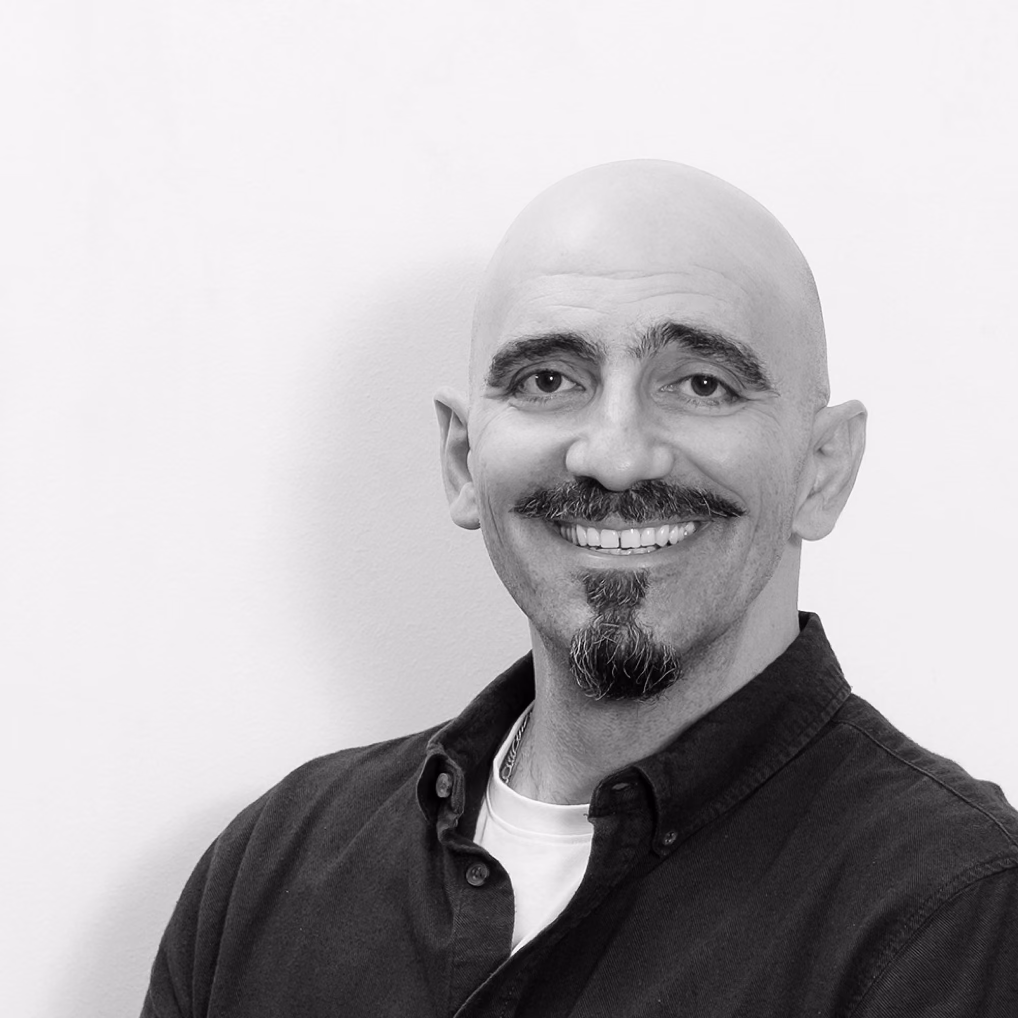 Wissam Sader, Senior Computer Generated Imagery at Nabil Gholam Architects, black and white portrait smiling in a dark buttoned shirt