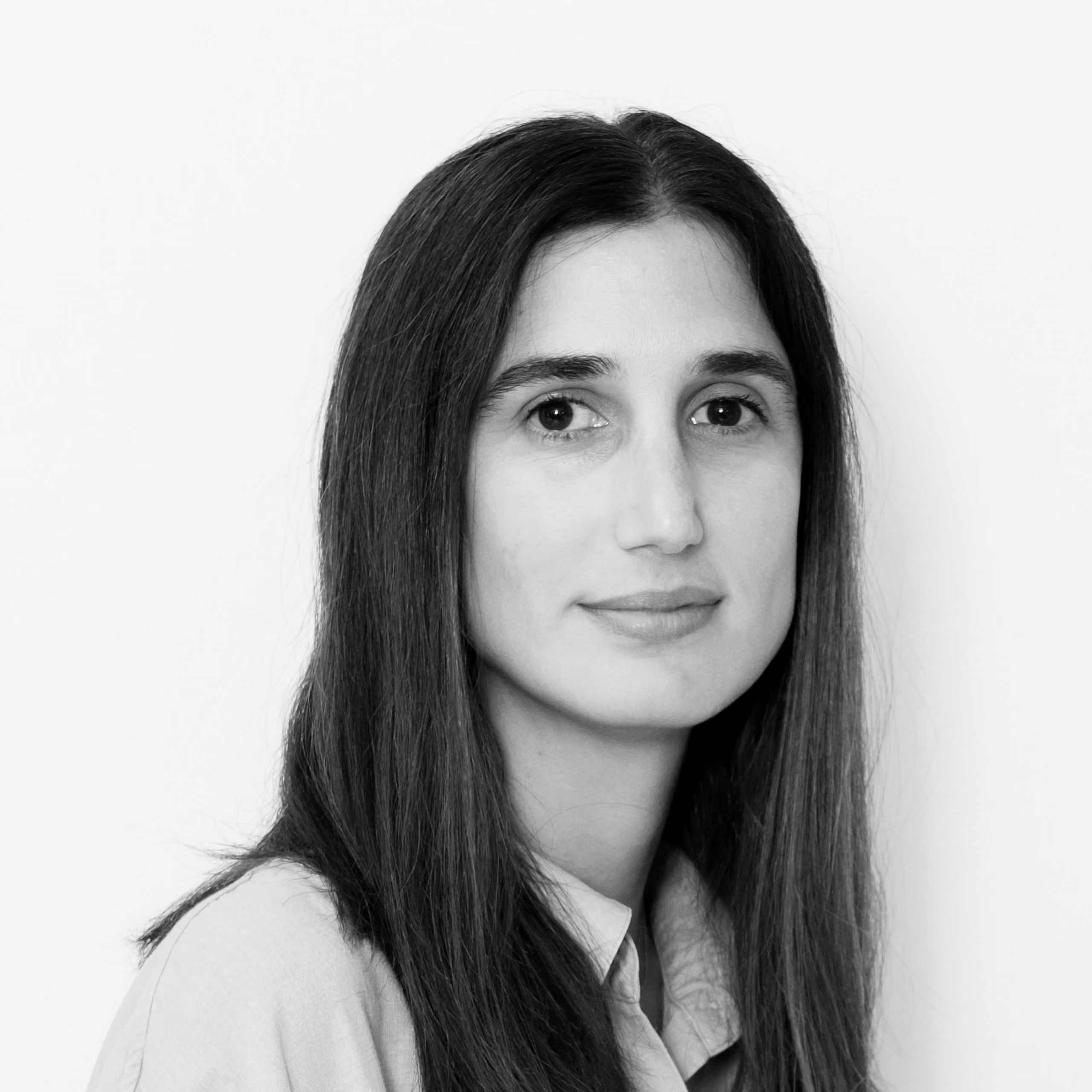 Cristina Fernández, Architect at Nabil Gholam Architects, black and white portrait with long dark hair and a light collared shirt