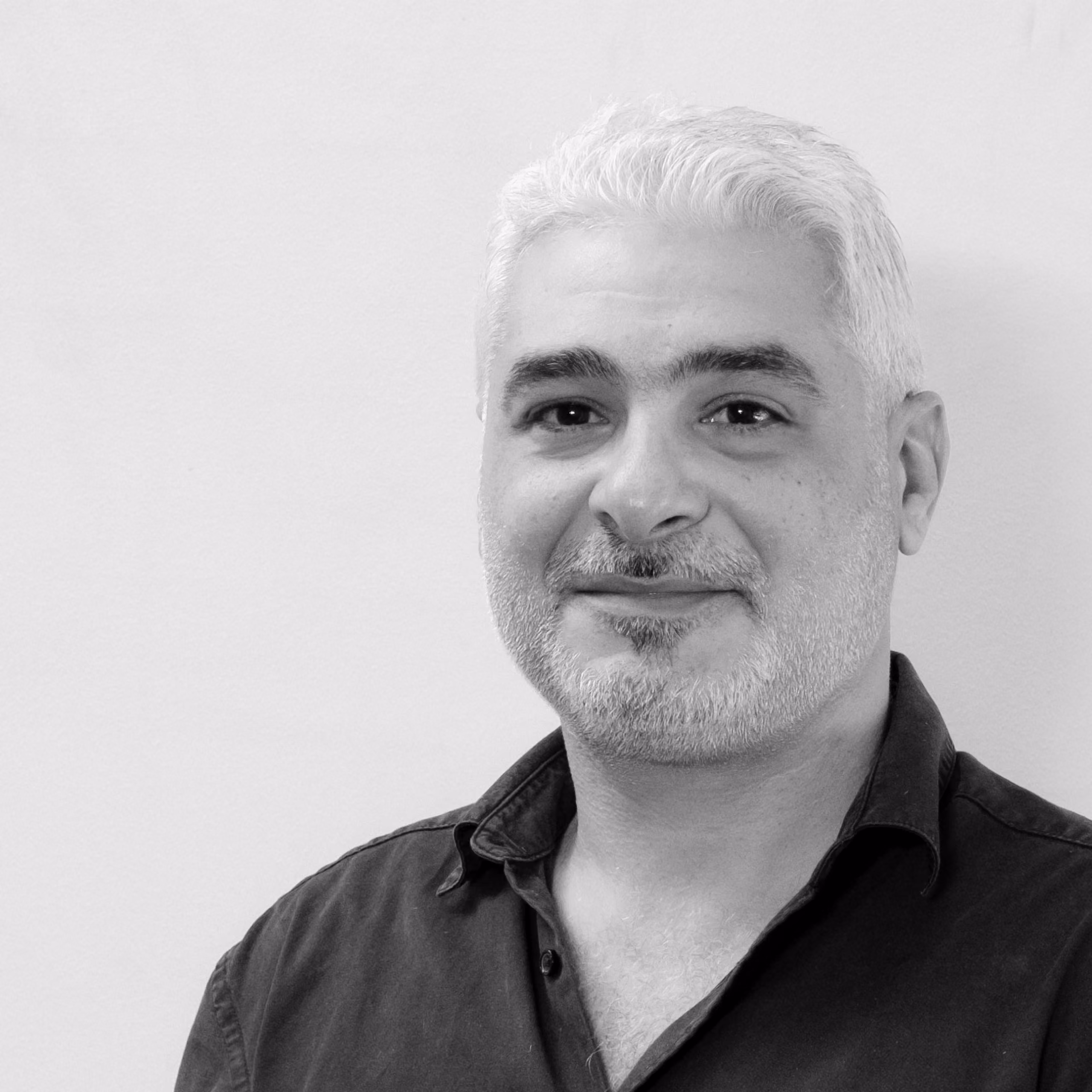Maroun Gédéon, Senior Architect at Nabil Gholam Architects, black and white portrait with short grey hair and beard, wearing a dark buttoned shirt