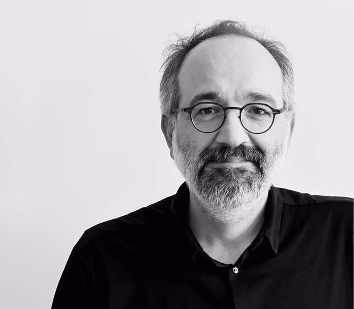 Raffy Doulian, Senior Lead Architect/Planner at Nabil Gholam Architects, black and white portrait with round glasses, a grey beard and dark buttoned shirt