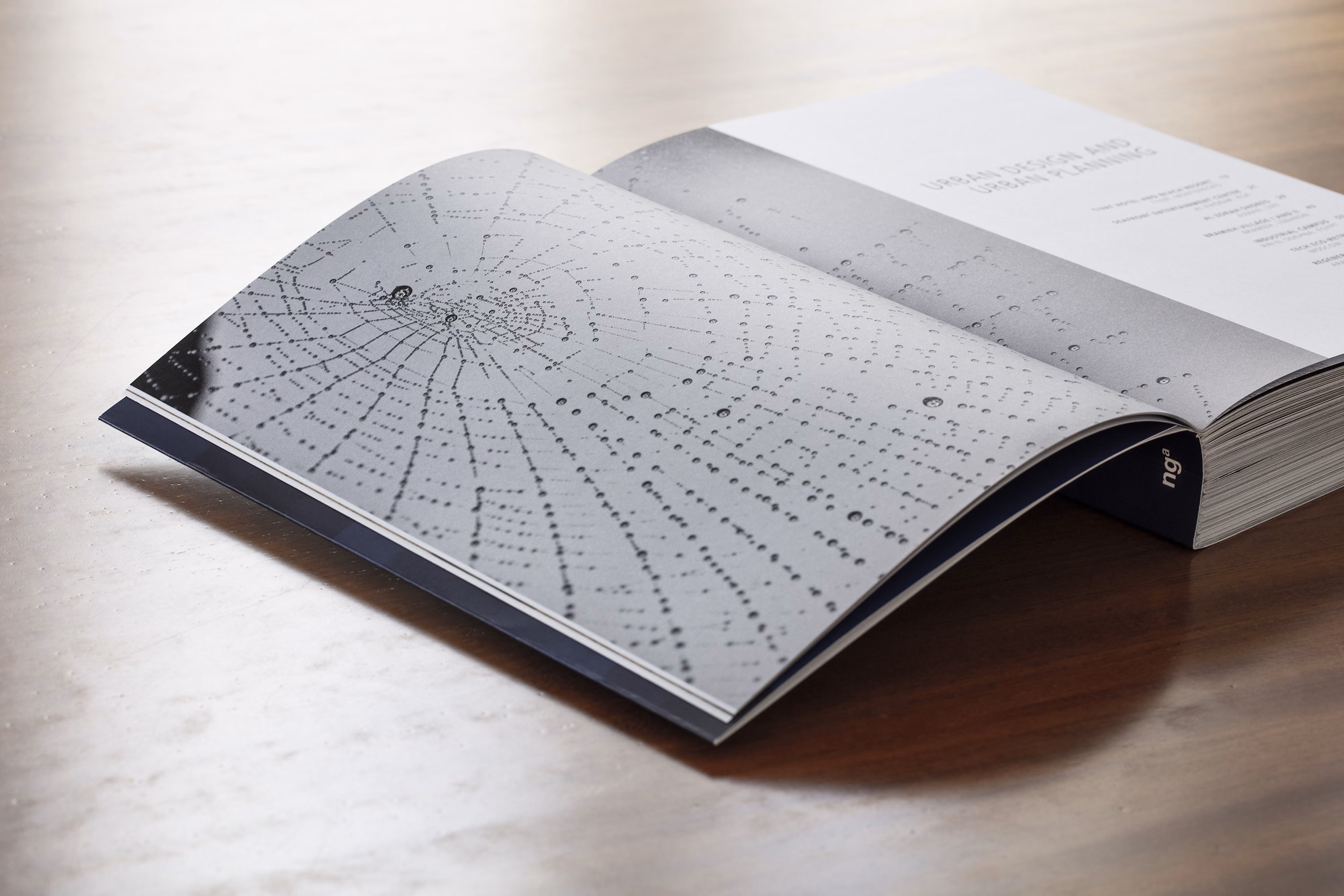 Open spread of Works 2025 showing a dew-covered spiderweb photograph beside the Urban Design and Urban Planning chapter title page