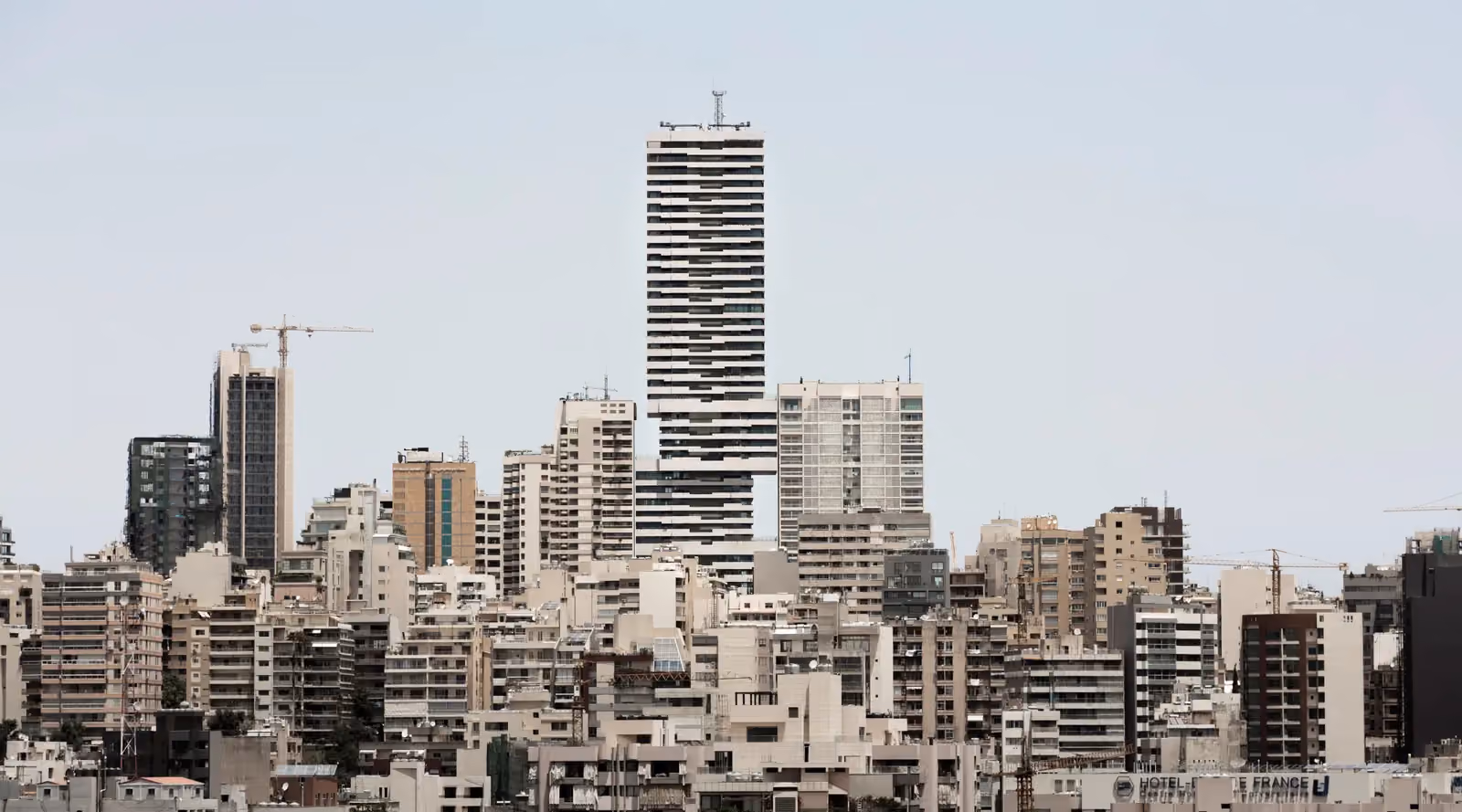 Skygate, a striated high-rise by Nabil Gholam Architects formed of four stacked cubical volumes, towering above Beirut's dense skyline, Lebanon