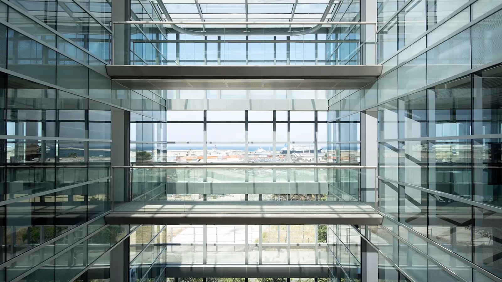 CMA-CGM Headquarters refurbishment in Beirut, Lebanon, by Nabil Gholam Architects, glazed atrium with floating glass bridges framing a distant sea view