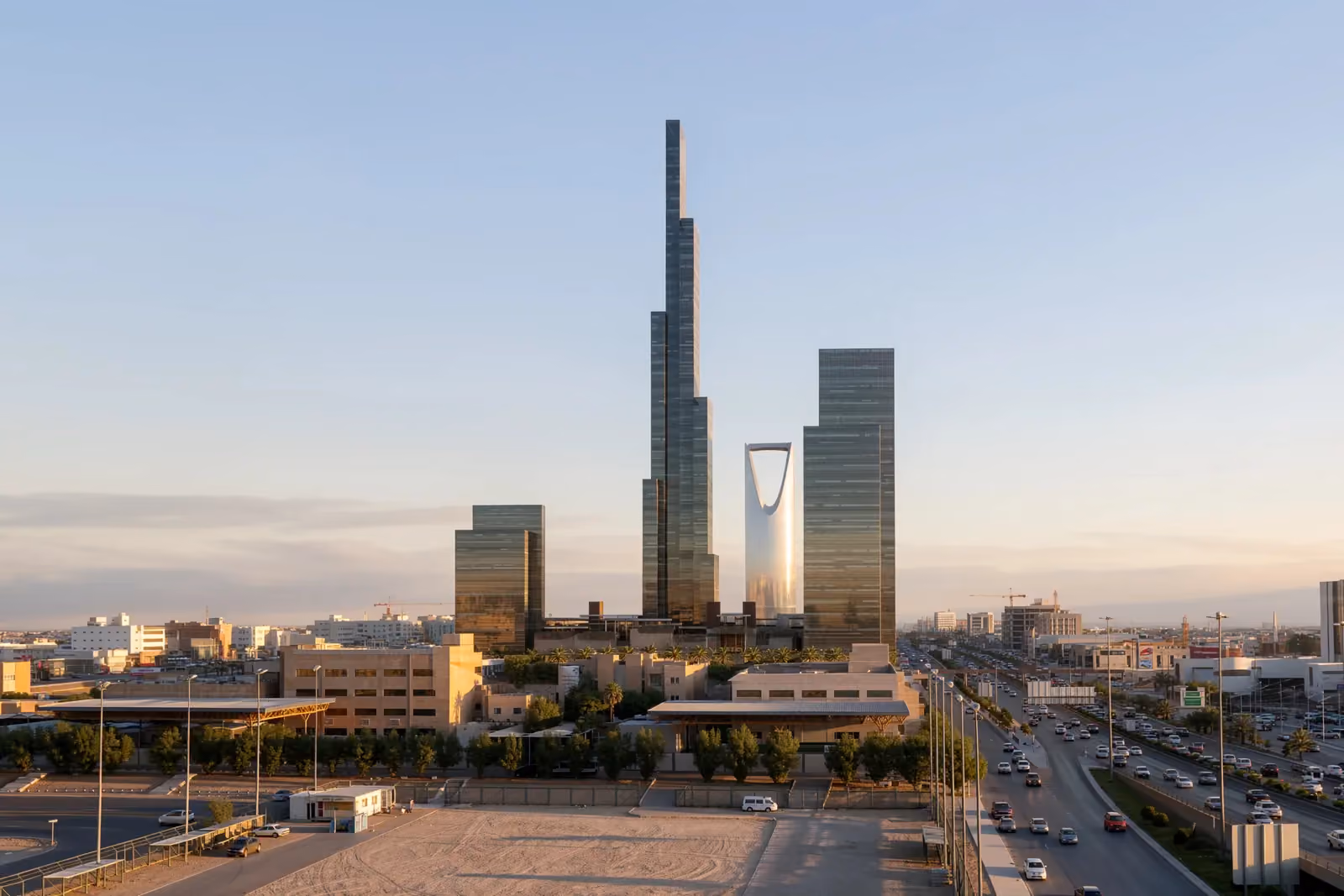 Mixed-Use Development in Riyadh by Nabil Gholam Architects, a tapering high-rise tower rising above lower glass buildings beside a busy highway at dusk