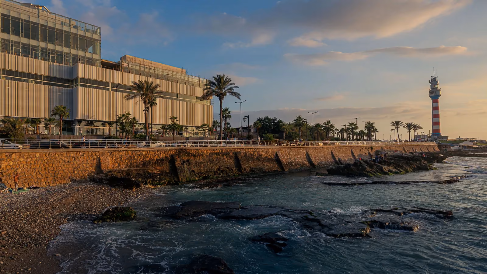 Dalfa Seafront, a mixed-use building by Nabil Gholam Architects, along Beirut's rocky Corniche with the Manara lighthouse in the distance, Lebanon