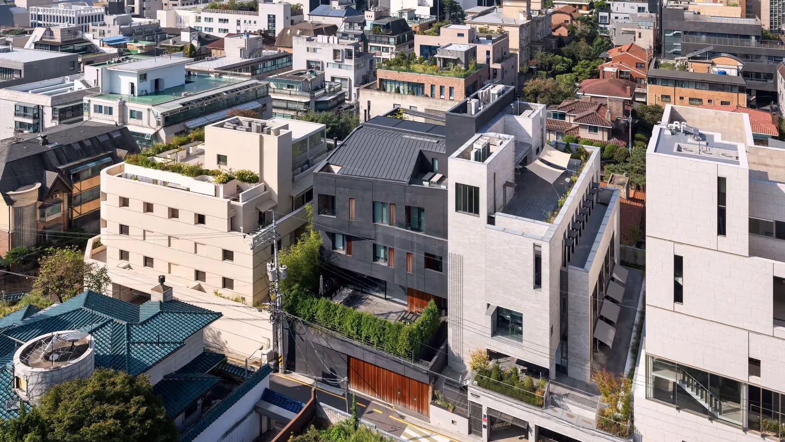 Pyrite, a dark faceted concrete residence by Nabil Gholam Architects, nestled among rooftops and townhouses in a dense Seoul neighbourhood, South Korea