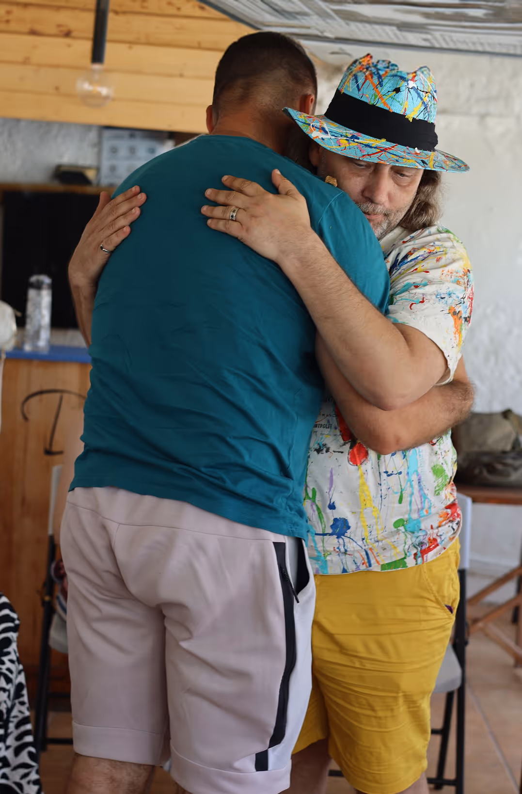 Два чоловіки міцно обіймаються в інтер'єрі кімнати — Enjoy 2026, Інтенсив MIGIS, інтенсив для гештальт-терапевтів