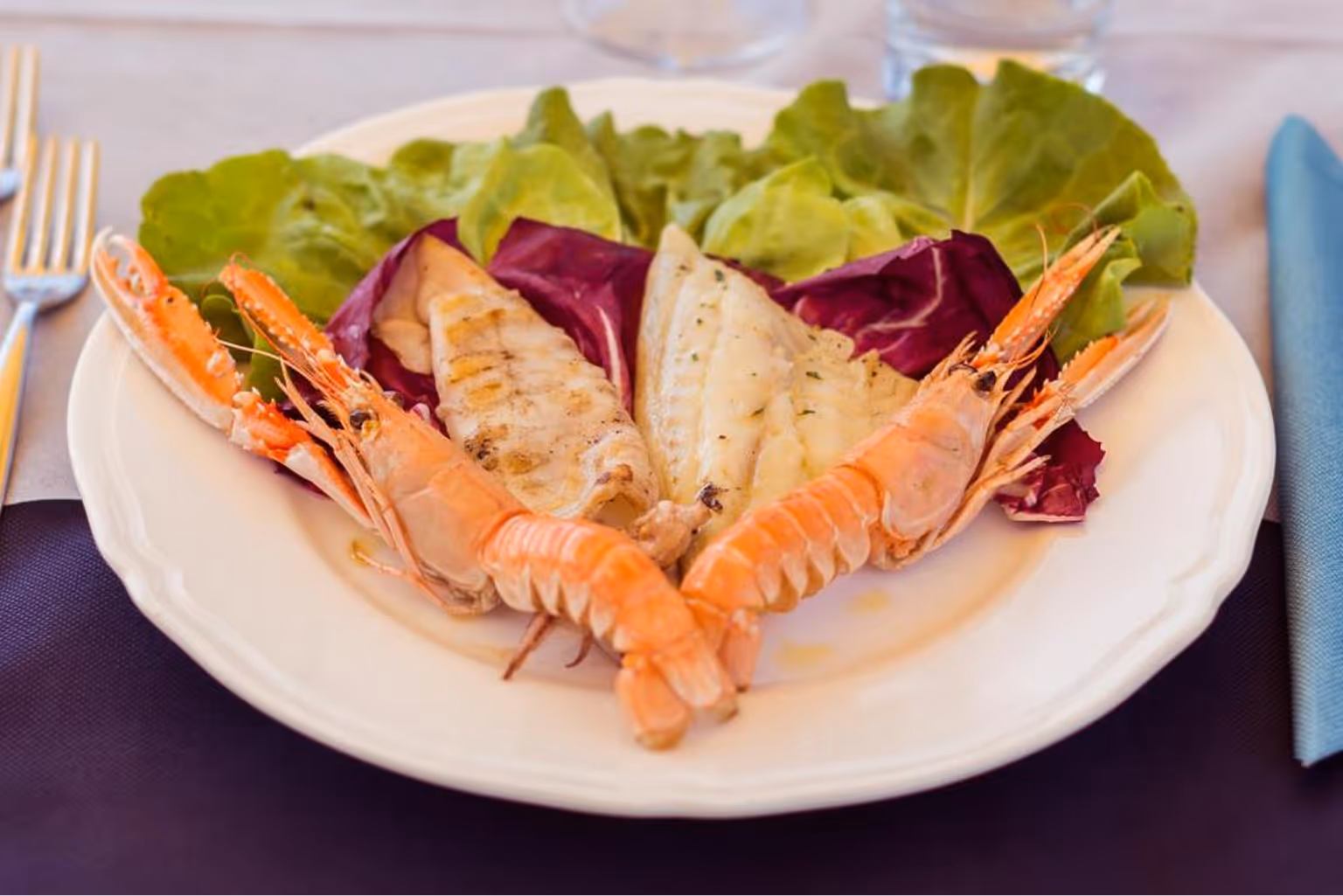 Тарілка з вареними раками, смаженою рибою та листям салату. Villaggio Mare Si