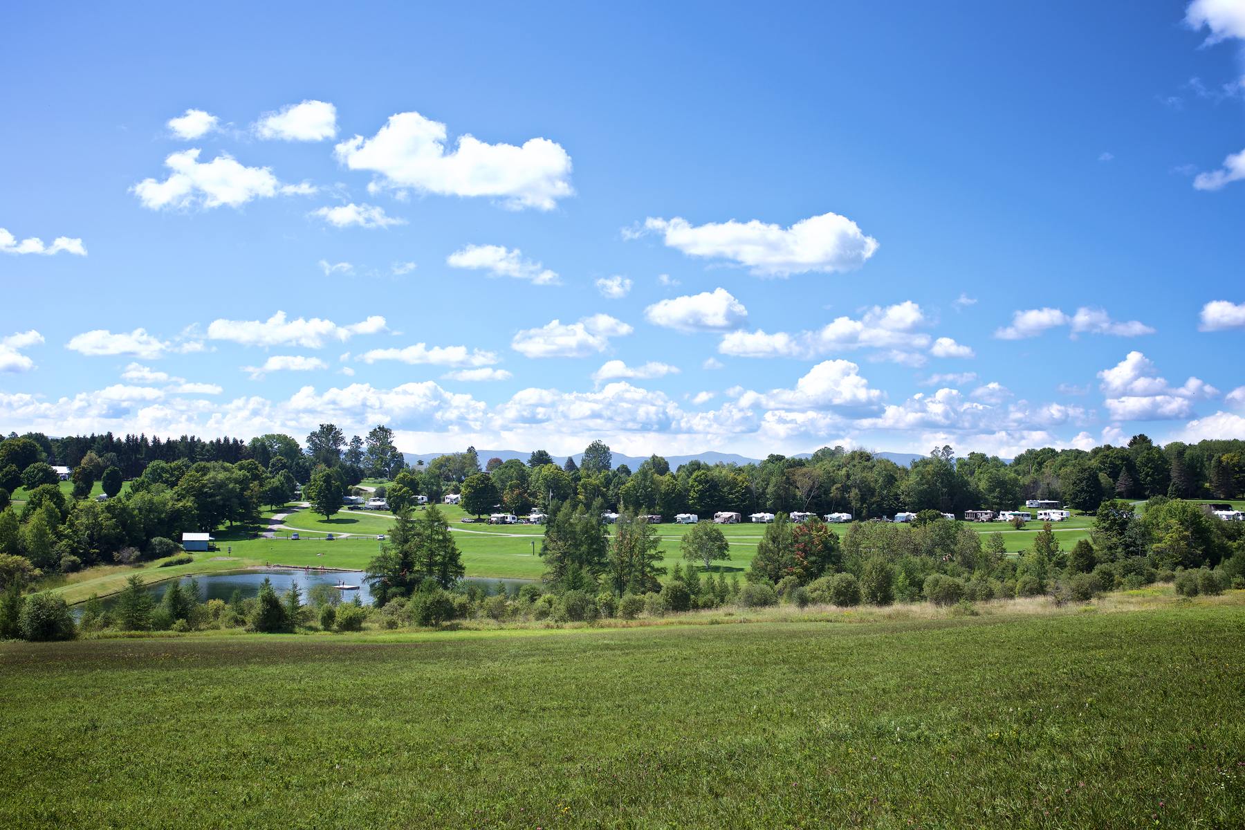 Rolling green hills and open fields at Lake Champagne Campground in Vermont