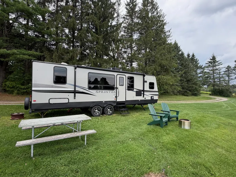 Lake Champagne rental RV at its outdoor site with a picnic table