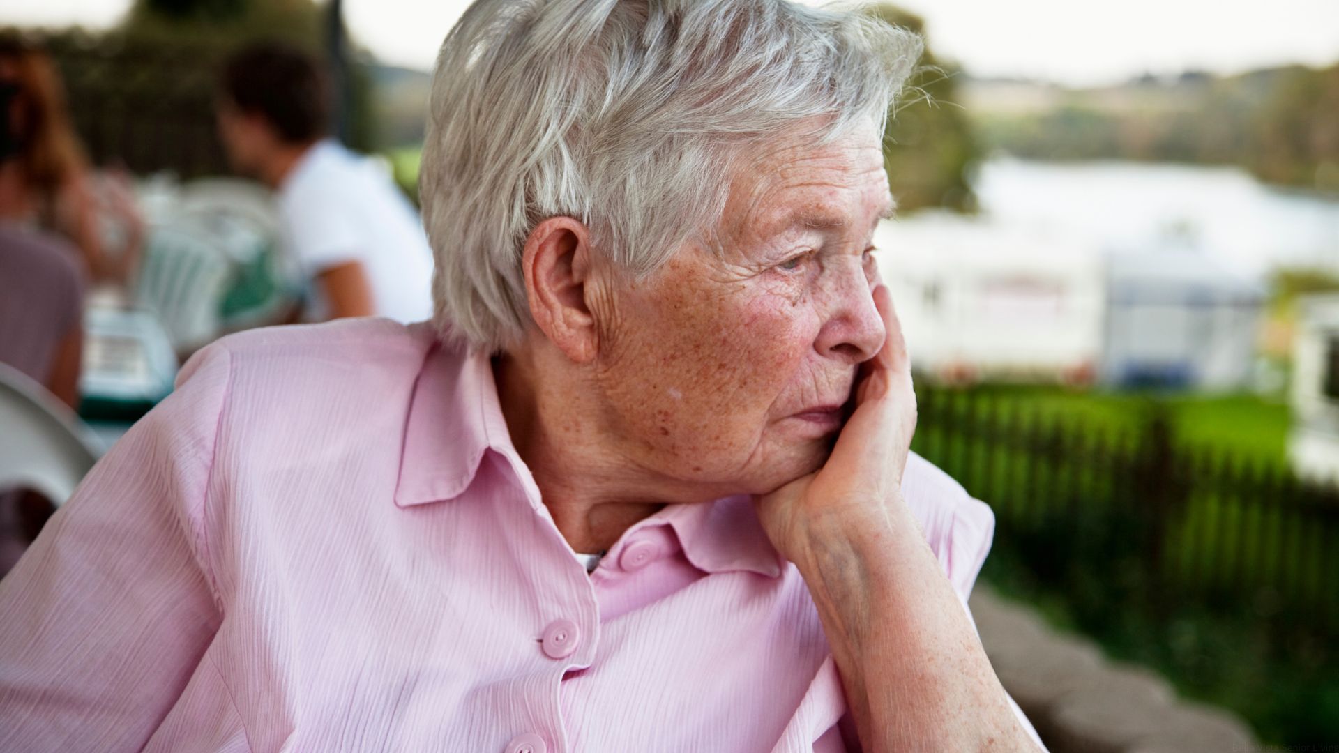 A senior woman worries about her partner in assisted living.