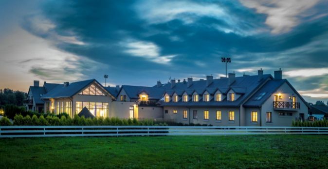 Niska zabudowa hotelowa w zielonym otoczeniu.