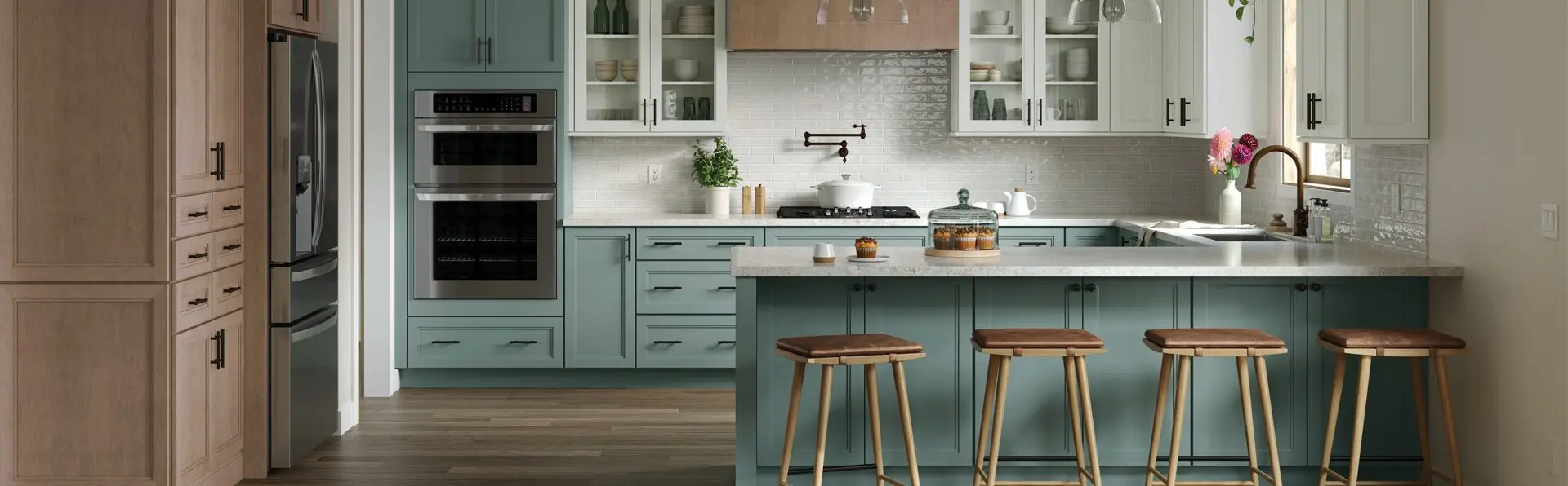Modern kitchen with teal cabinets, white countertops, wooden stools, and stainless steel appliances.