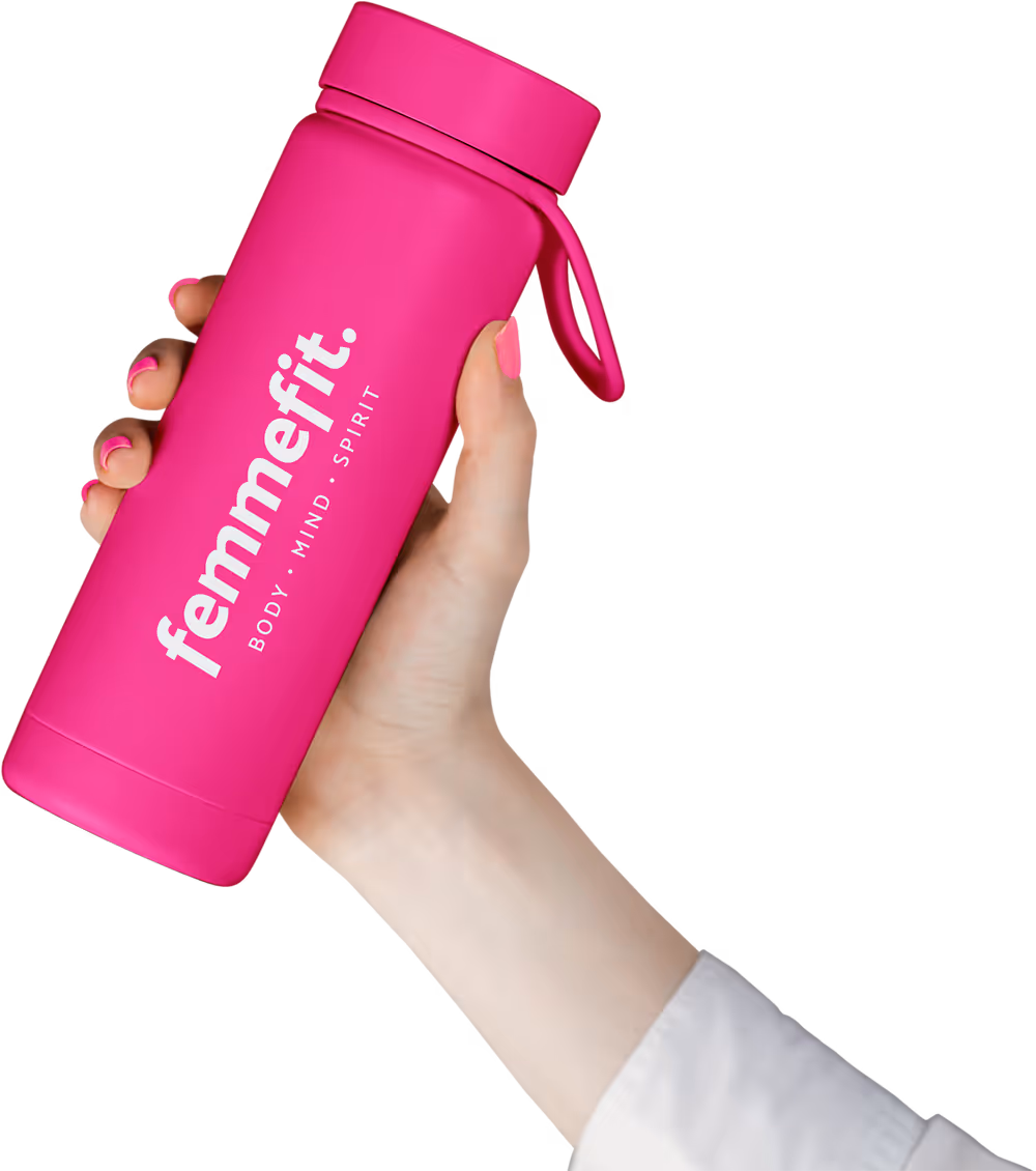 Hand holding a bright pink water bottle labeled 'femmefit. BODY · MIND · SPIRIT' with matching pink nail polish.