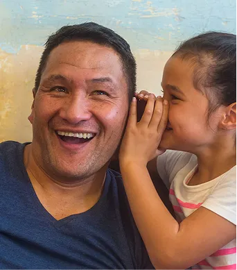 A man and a little girl sitting next to each other.