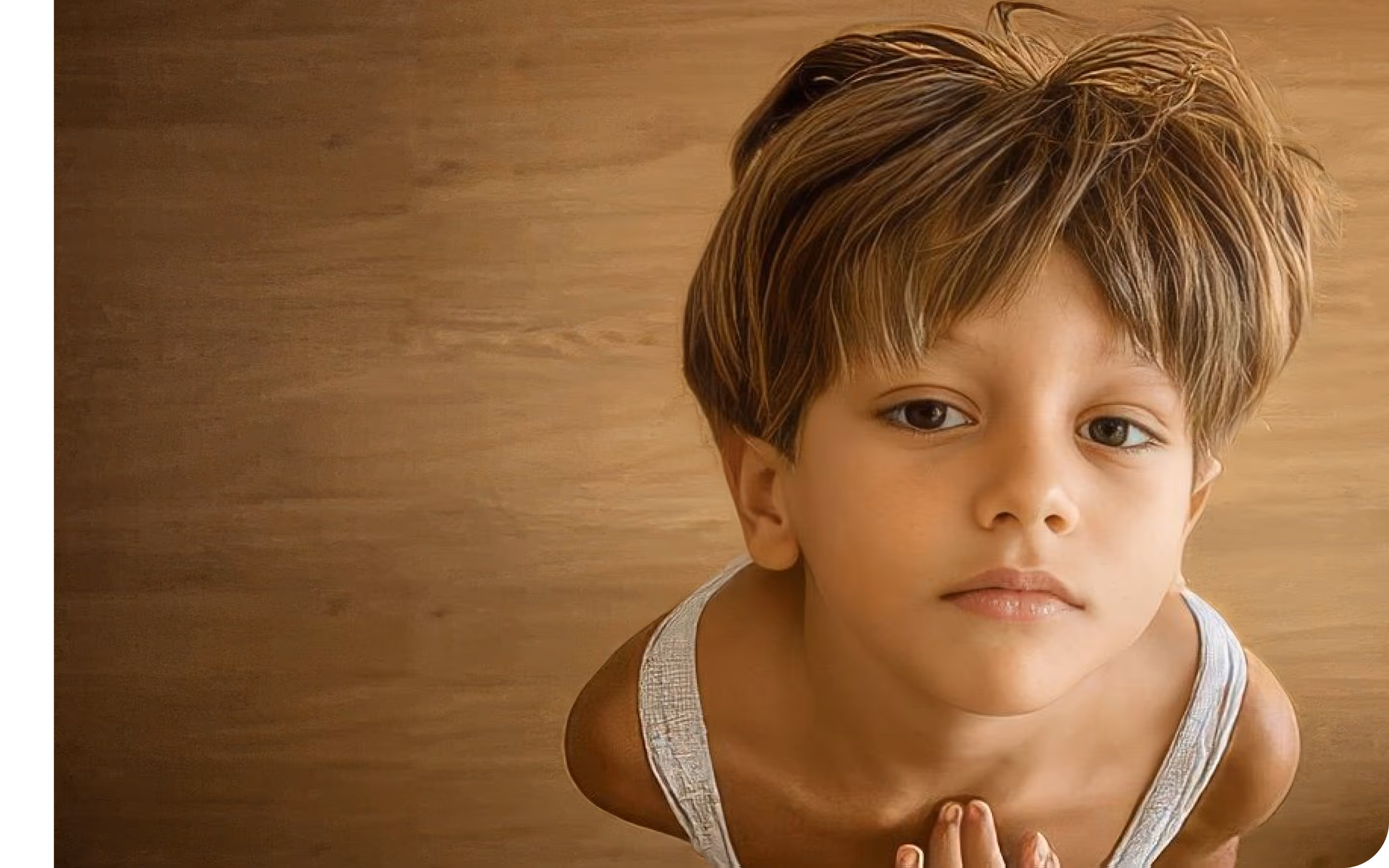 Young boy with tousled light brown hair and white tank top