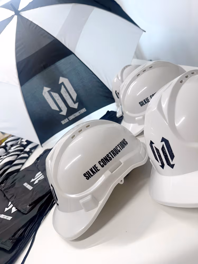 White construction helmets and gear branded with SILKIE CONSTRUCTIONS logo on a white surface.