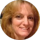 Smiling woman with curly blonde hair, likely an IT professional or business client at NET-i managed services