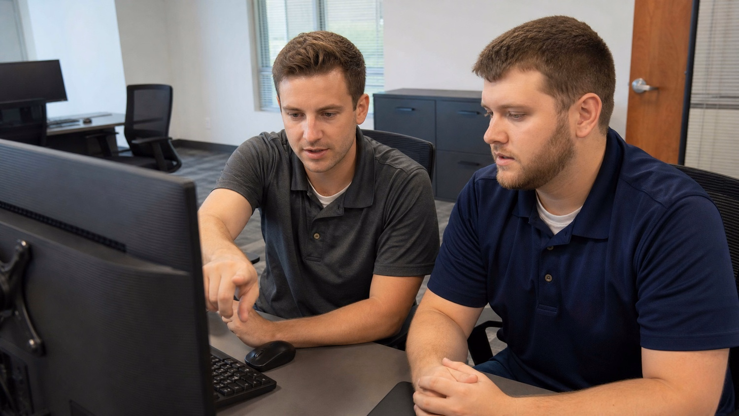 SIDE-BY-SIDE PAIR An IT professional two people seated side by side reviewin