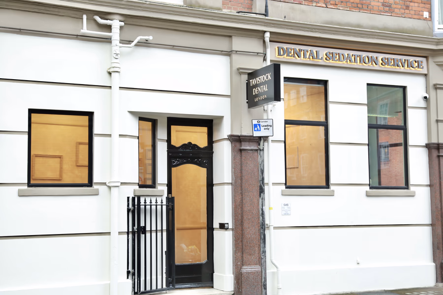 Exterior of Tavistock Dental London with black door and windows, sign reading Dental Sedation Service above.