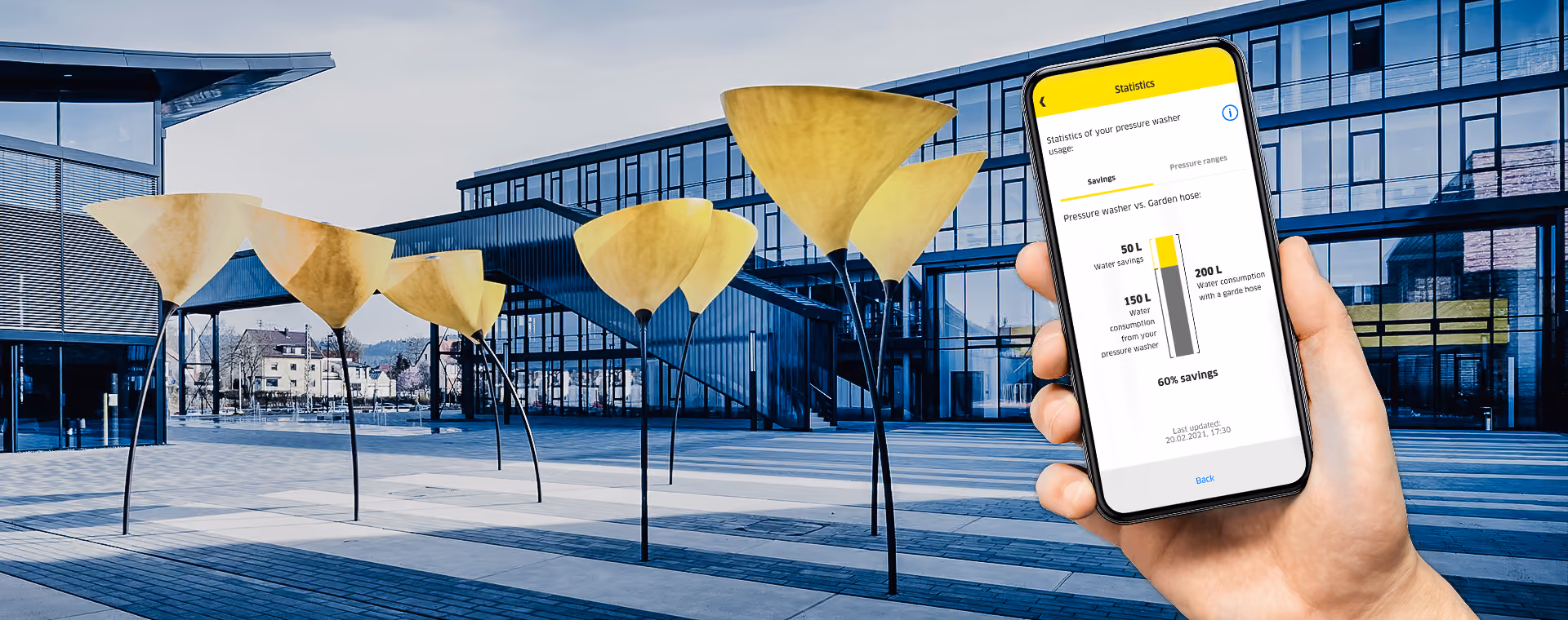 Handy in der Hand, auf dem die Statistik-App im Vergleich zu Wassereinsparungen im Gartenschlauch angezeigt wird.