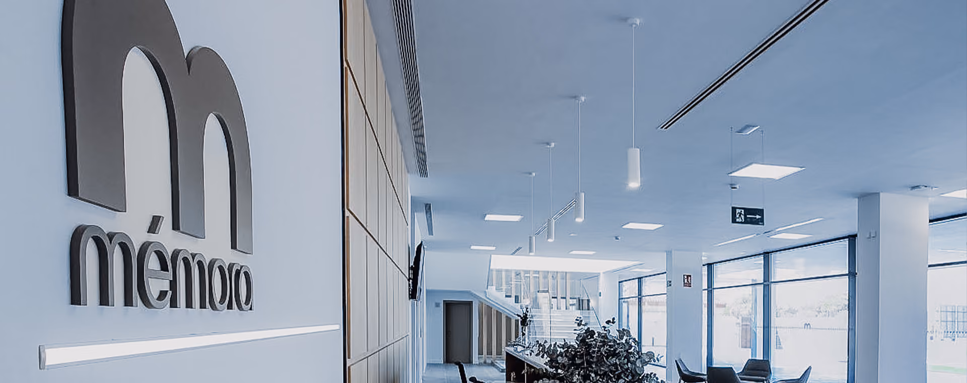 Moderne Bürolobby mit einem Memora-Logo auf weißer Wand.