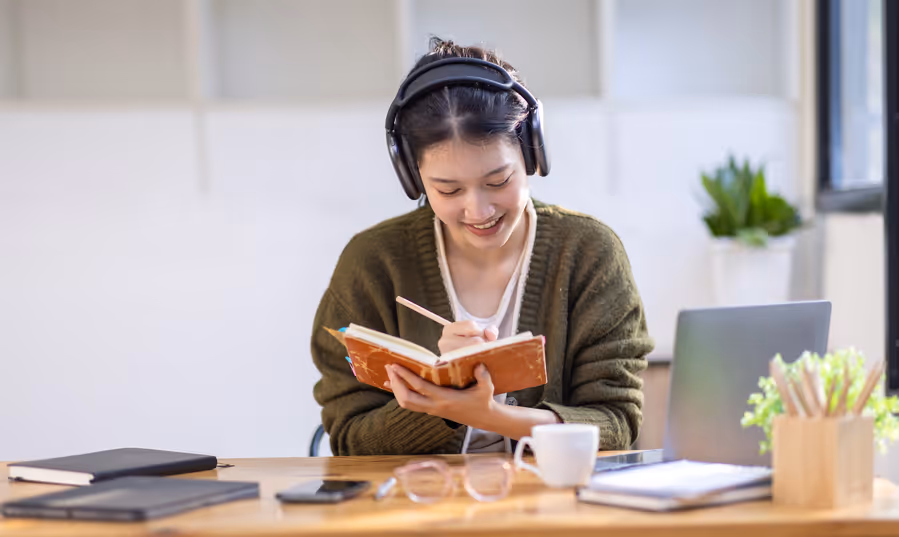 Jeune étudiante souriante étudie et lit un livre