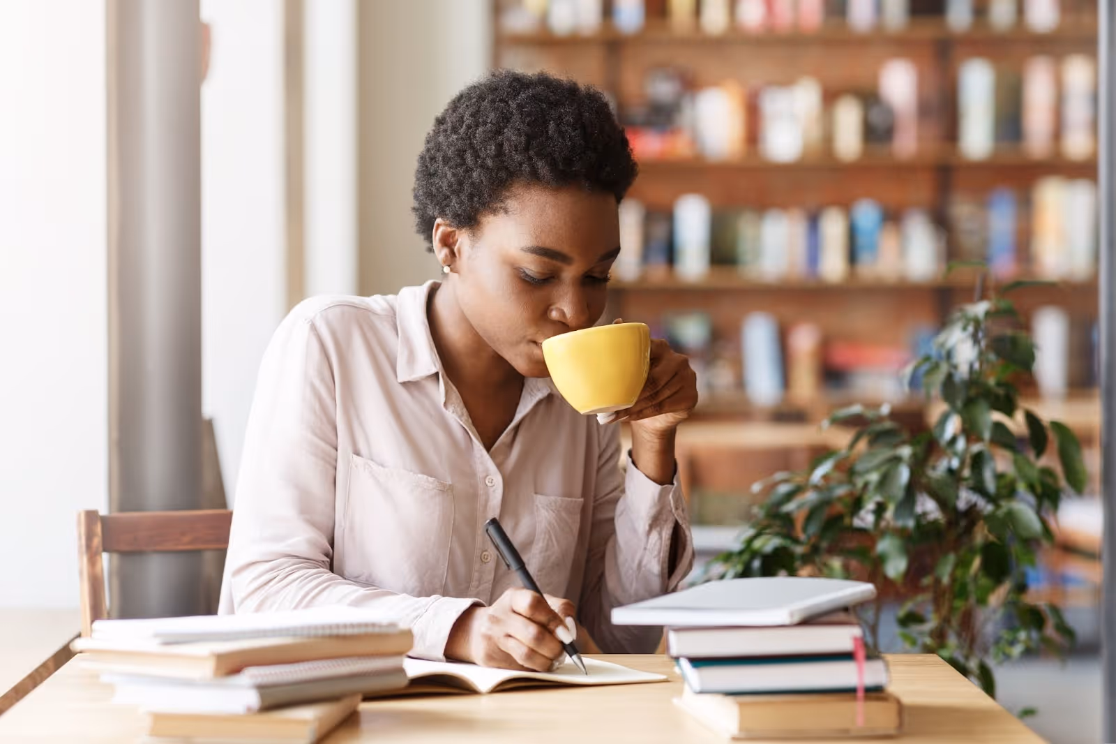 Jeune femme révise en buvant un café