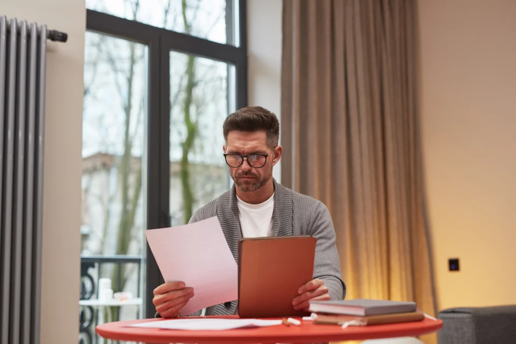 Propriétaire vérifiant la fiche synthétique de sa copropriété avant de signer un compromis de vente