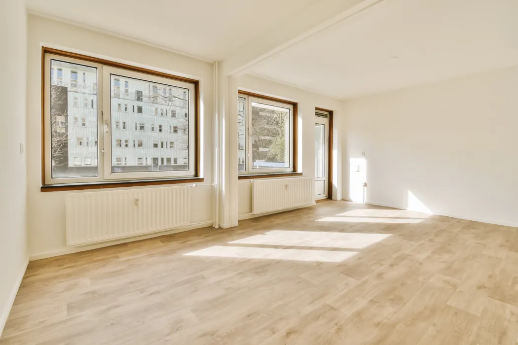 Une pièce à vivre moderne, vide et baignée de lumière naturelle, symbolisant le logement libéré et prêt pour un nouvel état des lieux suite au décès du locataire.