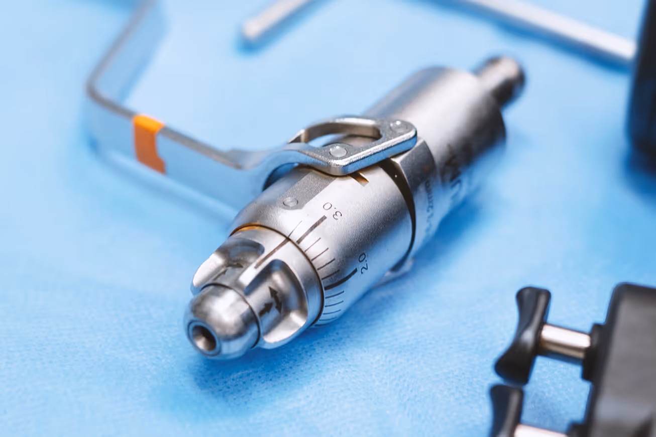 Close-up of precise medical instruments with millimeter scale used for veterinary orthopedic surgery on a blue sterile background.