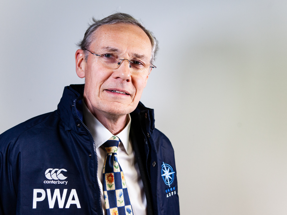 Older man wearing glasses and a navy jacket with 'PWA' and Canterbury branding.