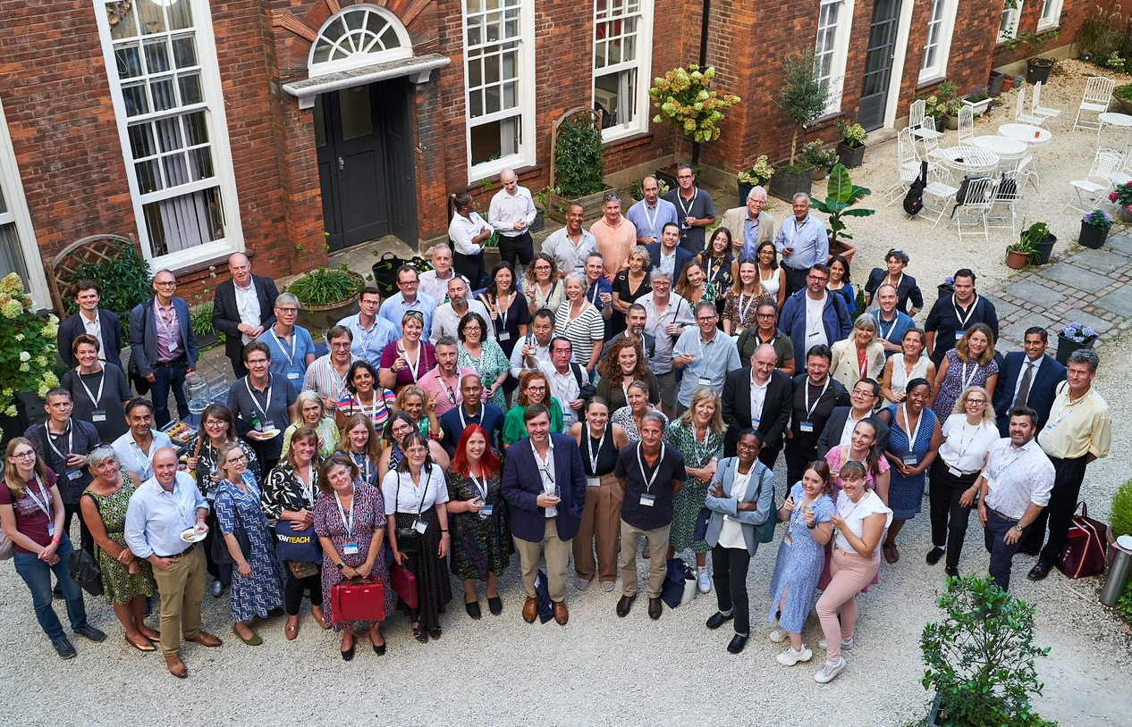 Large group of Now Teach career-changers and staff gathered outside a Georgian building, wearing lanyards.
