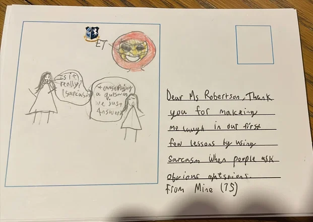 Handwritten postcard to Ms Robertson thanking her for using sarcasm to make lessons fun, with a pupil drawing.