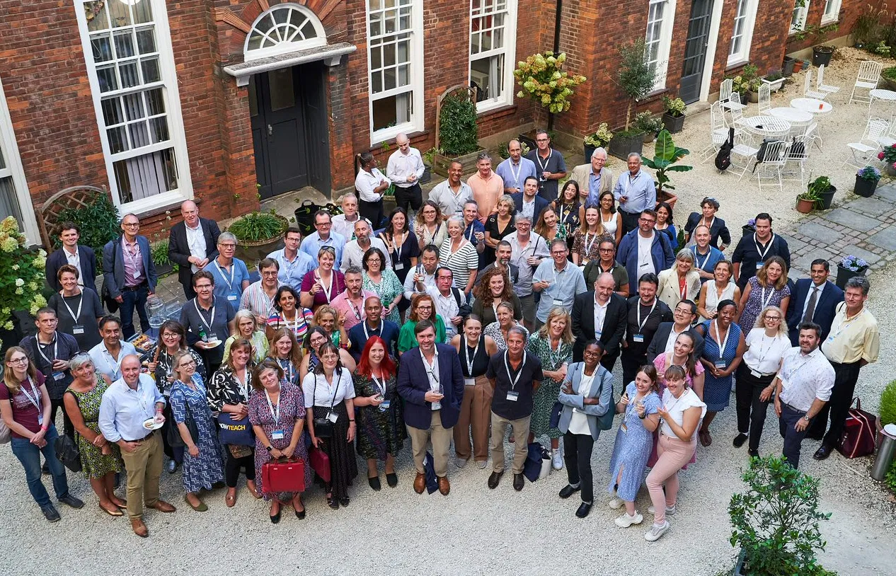 Large group of Now Teach career-changers and staff gathered outside a Georgian building, wearing lanyards.